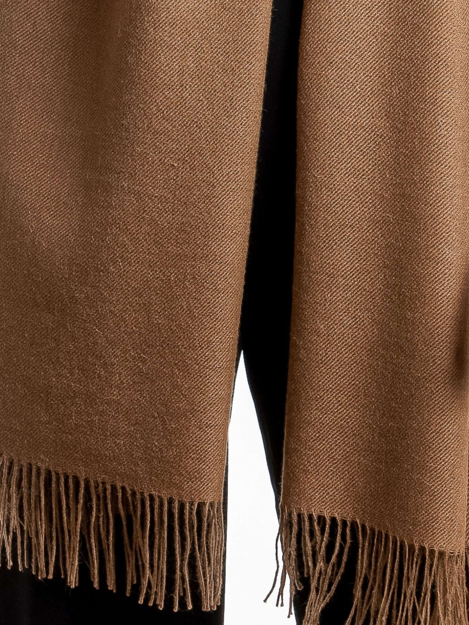 Close-up of soft alpaca wool shawl showing luxurious light fibre texture in camel brown