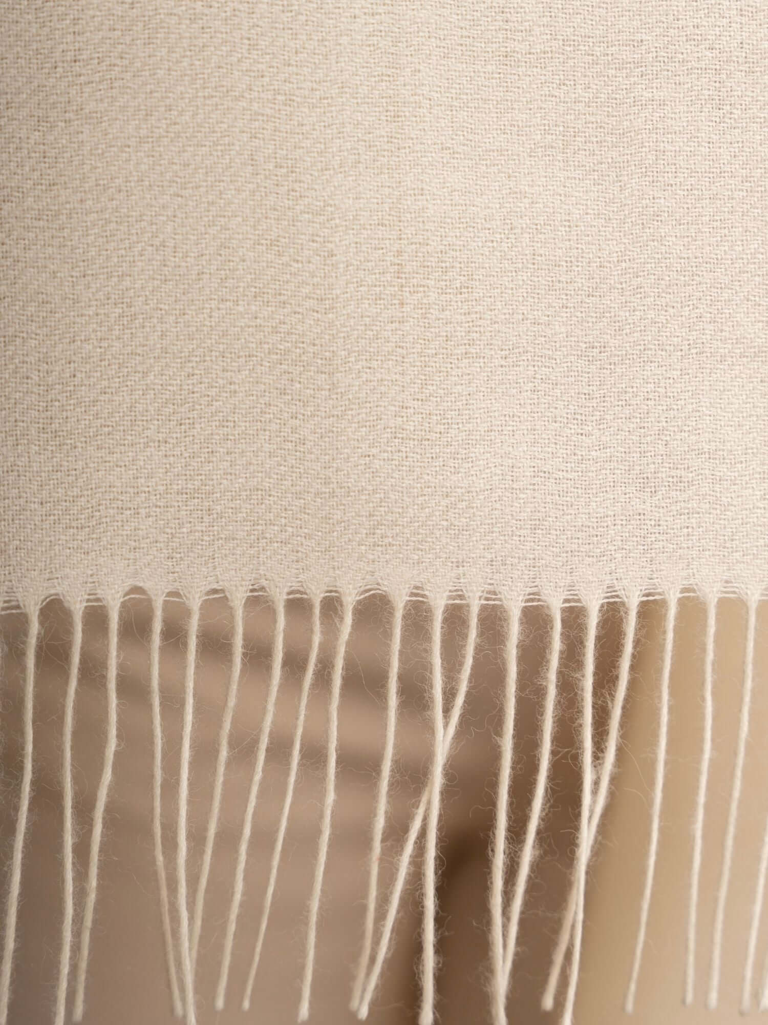 Close-up of soft alpaca wool shawl showing luxurious light fibre texture in ivory