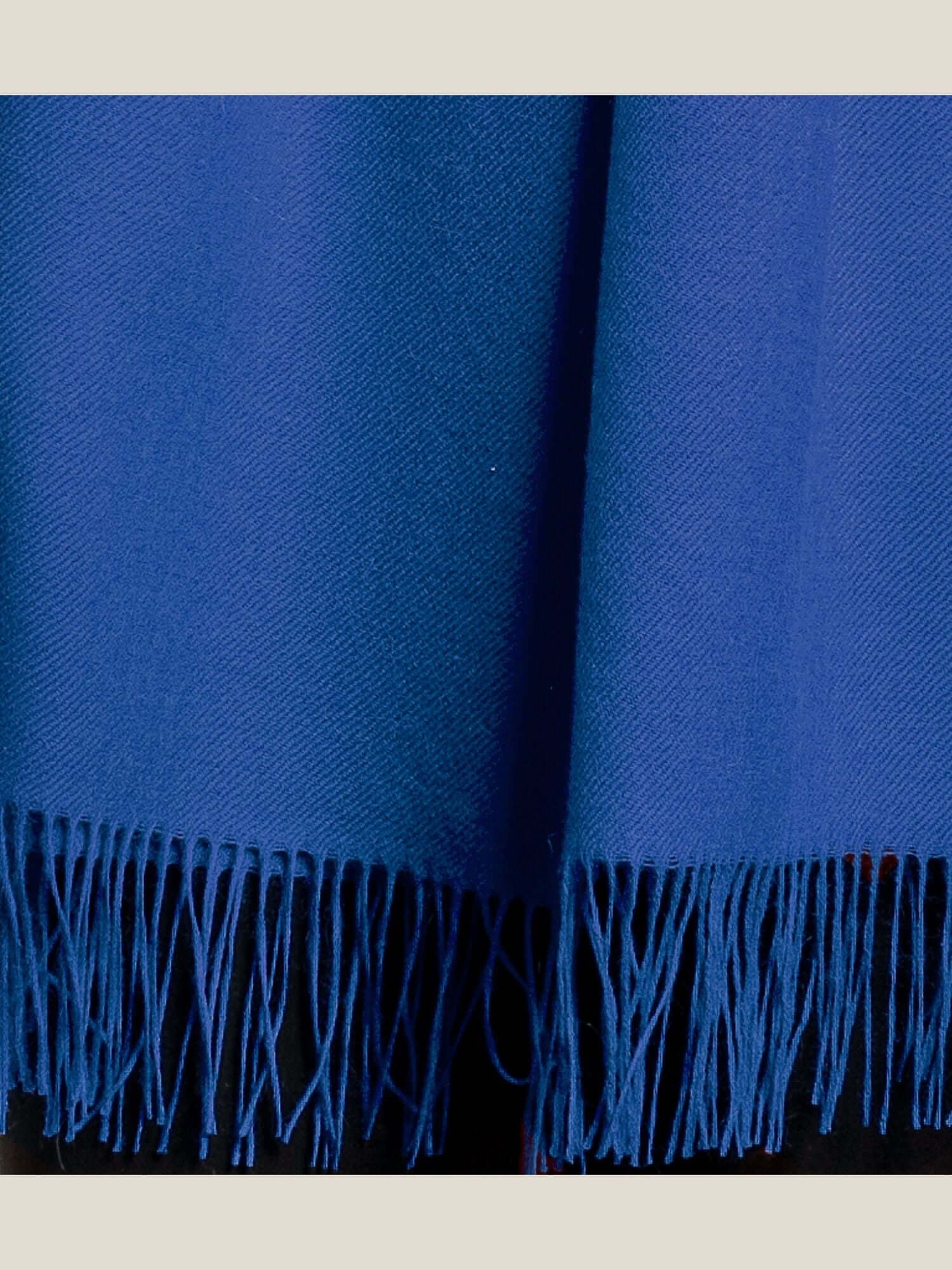 Close-up of soft alpaca wool shawl showing luxurious light fibre texture in electric blue