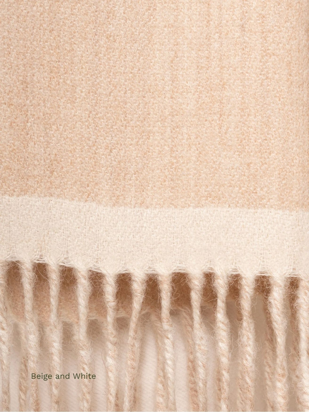 Close-up of the white edge and fringe on a beige and white double face baby alpaca scarf