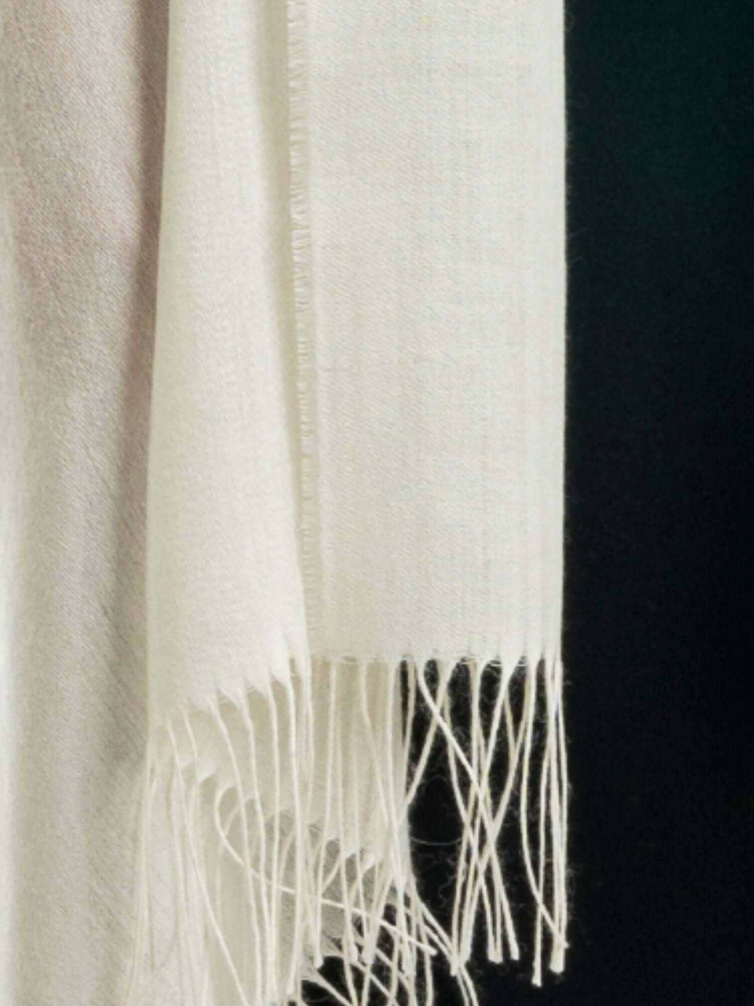 Close-up of soft alpaca wool and shiny silk shawl showing luxurious fibre texture in white