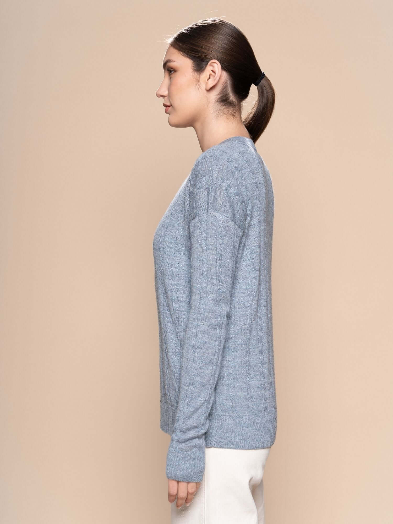Side view of blue grey alpaca jumper with curved hem and relaxed fit design