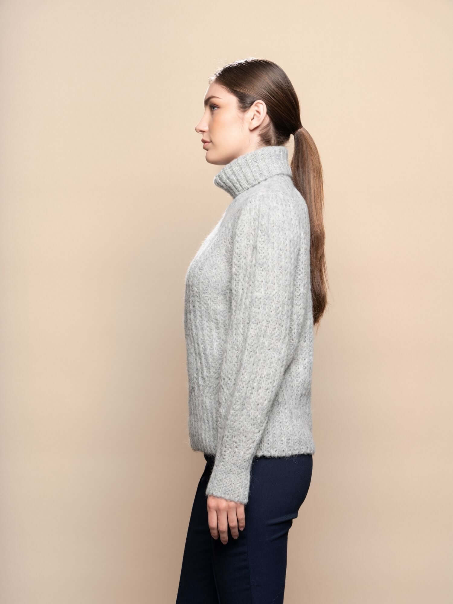 Close-up of light grey baby alpaca jumper, ultra-soft knit turtleneck with fine texture