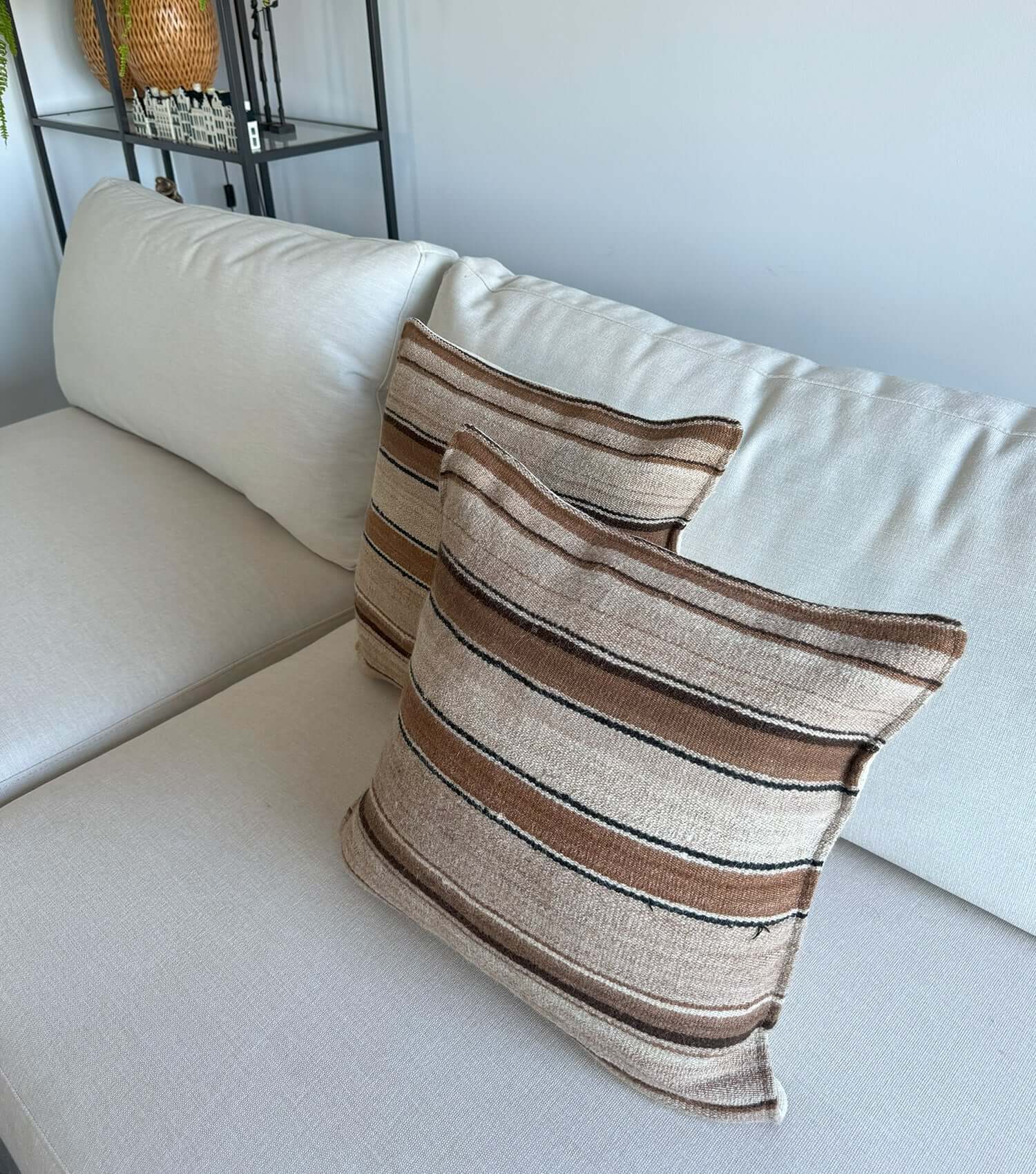 Decorative square pillow No.15 styled on sofa showing ethnic pattern and luxury wool texture in earthy tones