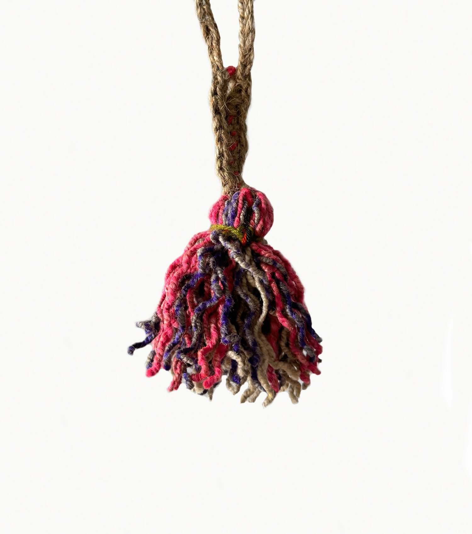 Small decorative wool tassel styled on handbag showing versatile accessory styling