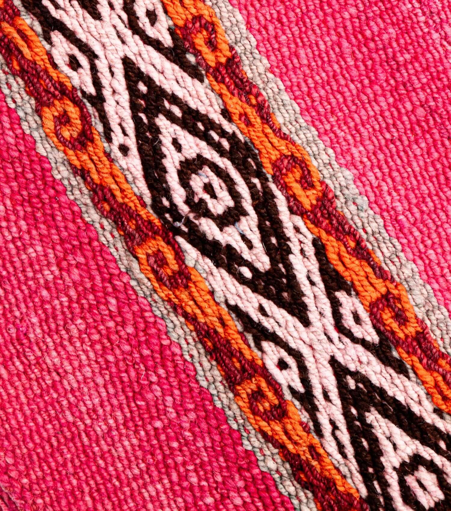 Close-up of traditional Peruvian weaving technique showing intricate washed fuchsia and brown pattern detail - frazada no 1