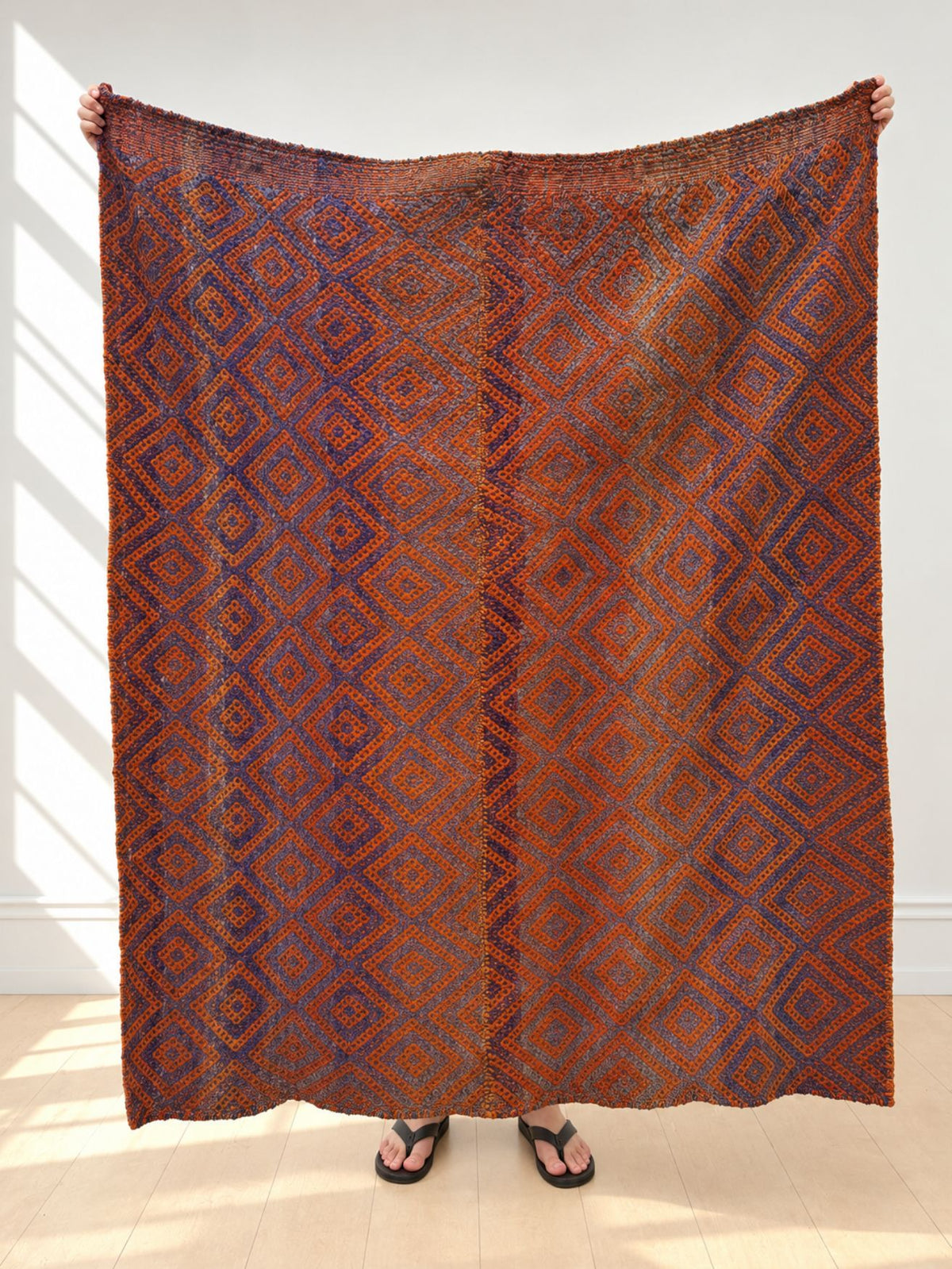 Vintage frazada rug No. 12 held up in full — rust orange and indigo blue, handwoven Peruvian sheep and alpaca wool, 159 × 150 cm | Orange Inca