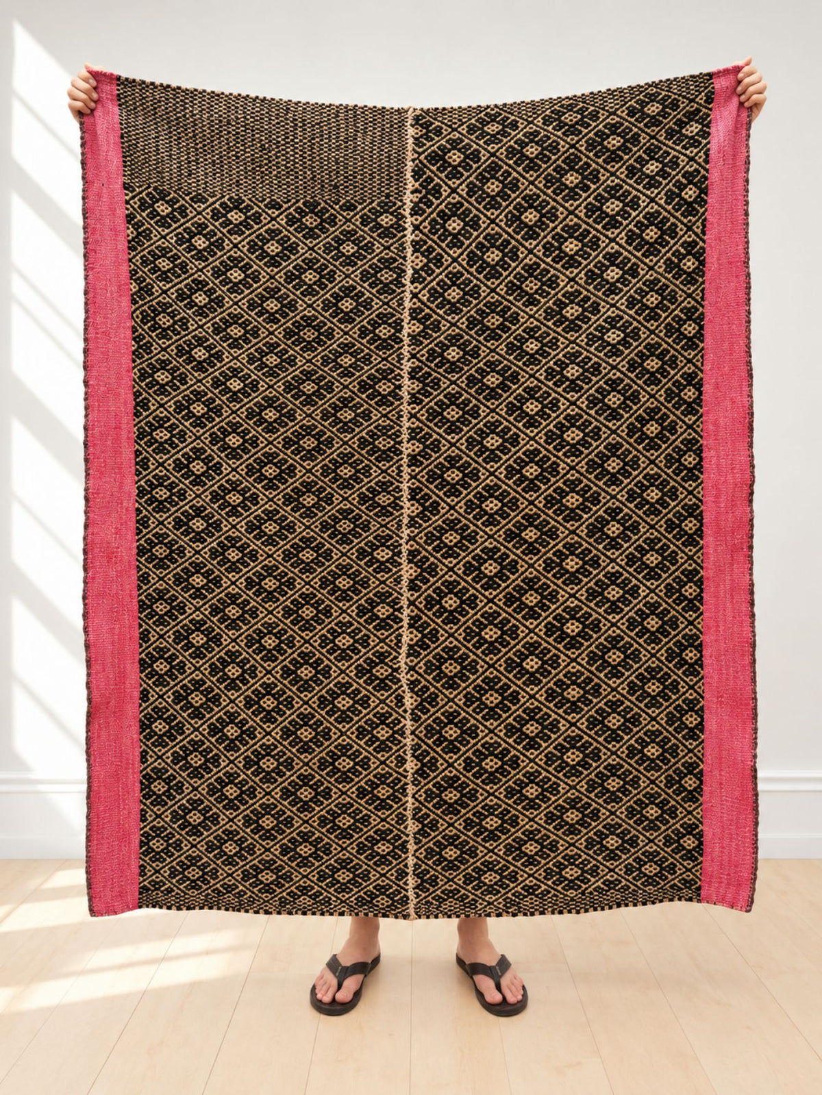Vintage frazada rug No. 9 held up in full — black, cream and hot pink, handwoven Peruvian sheep and alpaca wool, 150 × 140 cm | Orange Inca