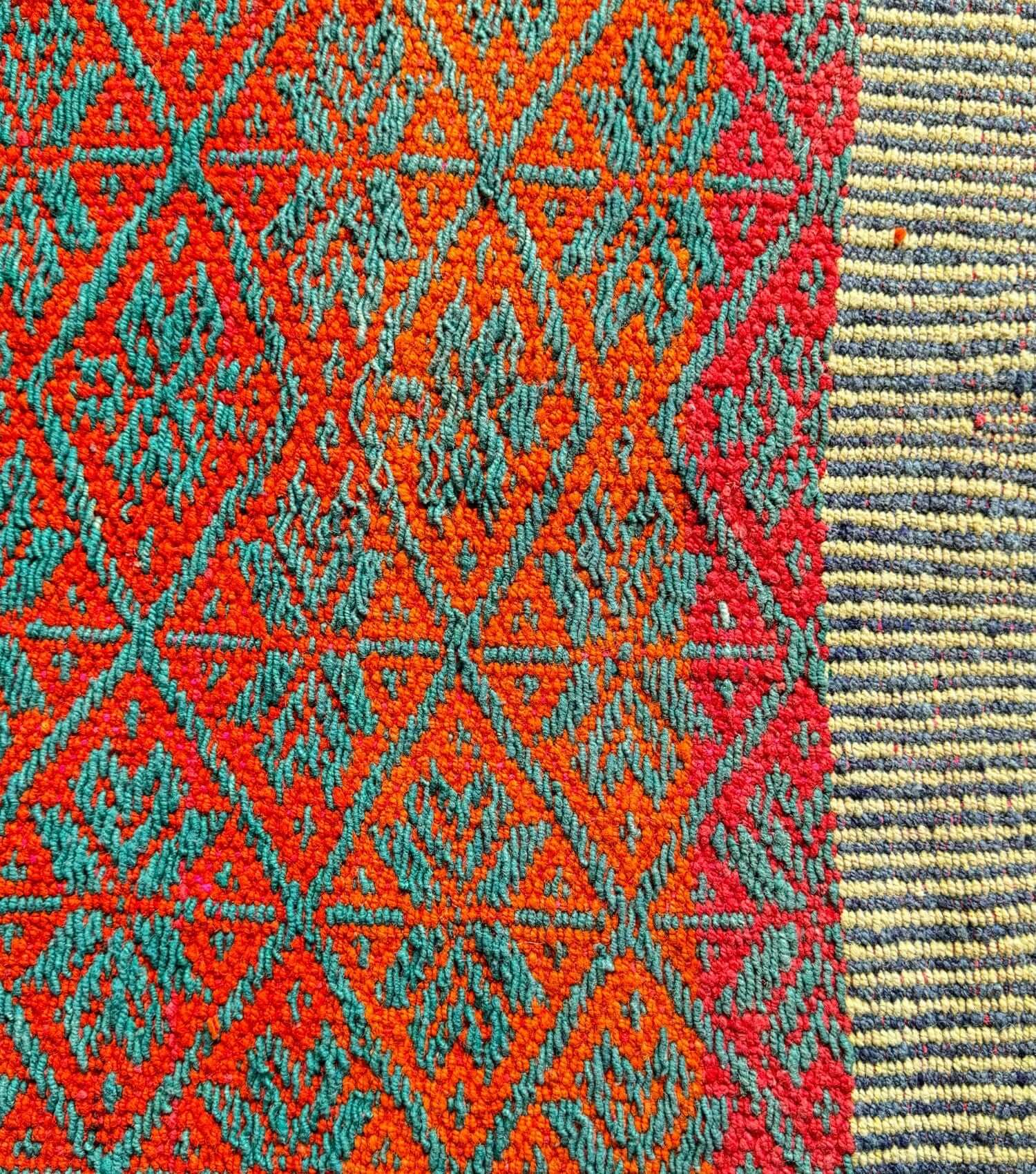Close-up of traditional Peruvian weaving technique showing intricate washed orange, yellow and green pattern detail - frazada no 16