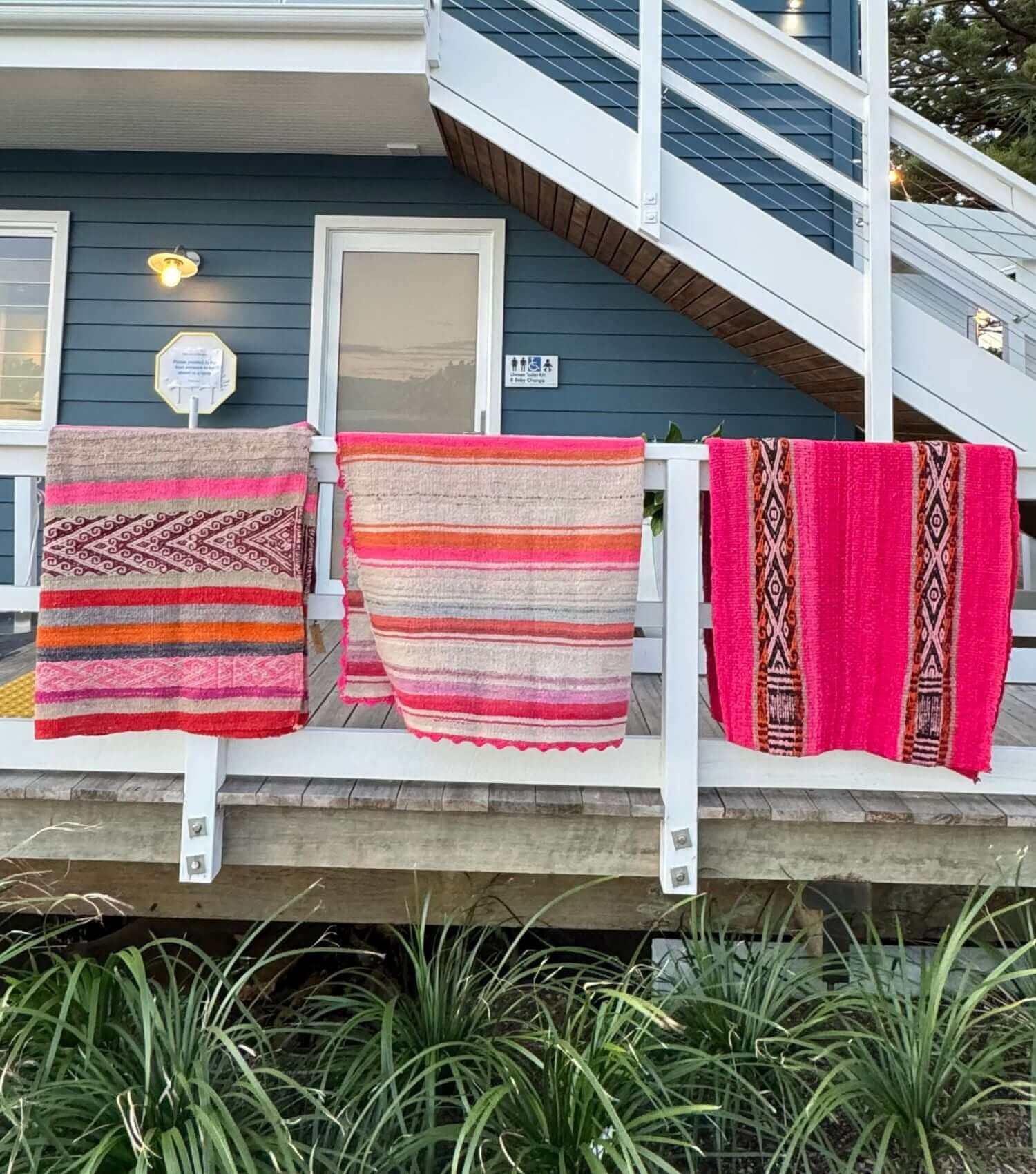 Peruvian frazada textile art displayed as throws hanging at a beach deck showing full pattern and scale