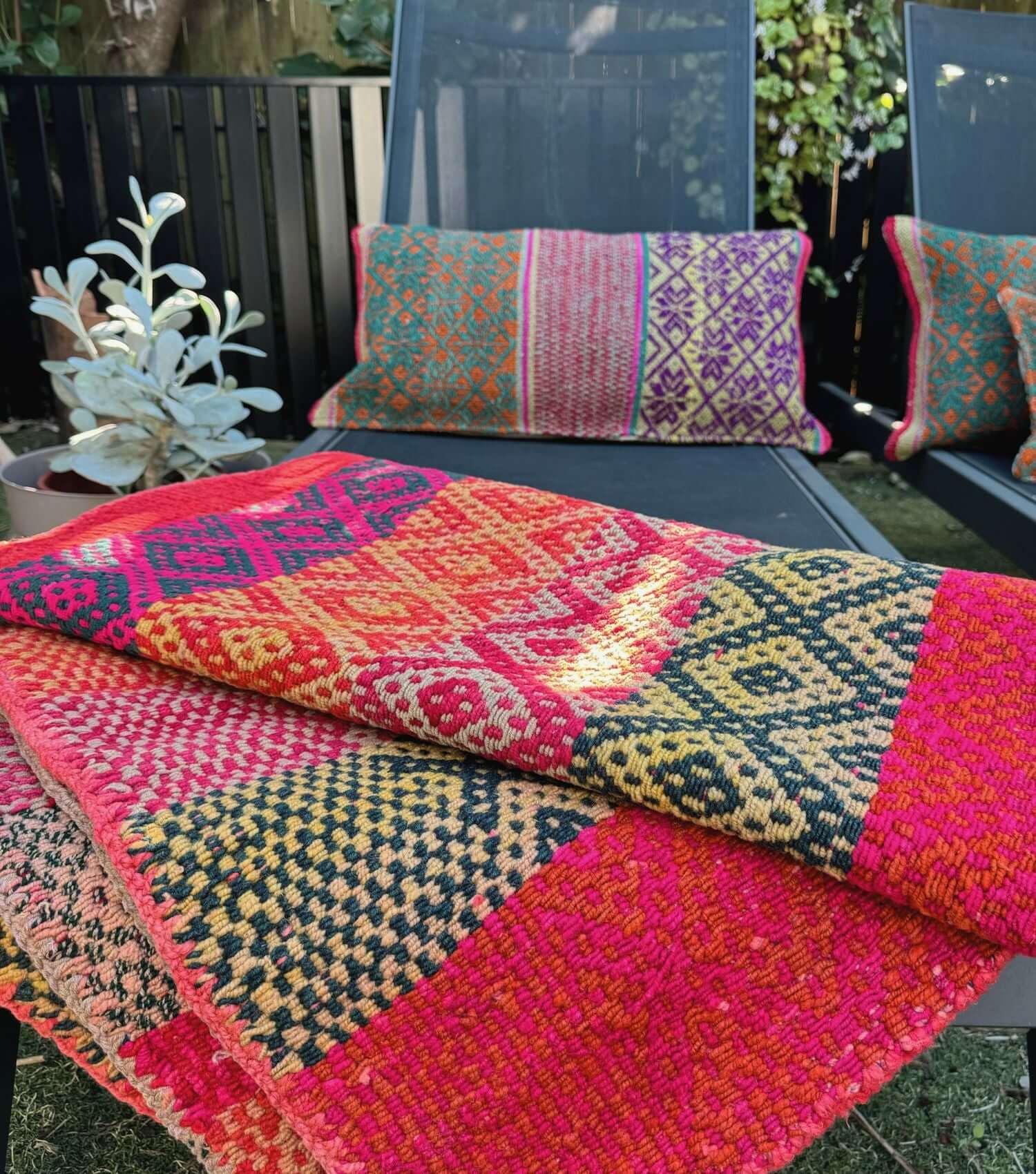 Peruvian wool throw no 2 styled as outdoor throw and blanket showing bohemian pattern in washed red, yellow, orange and blue