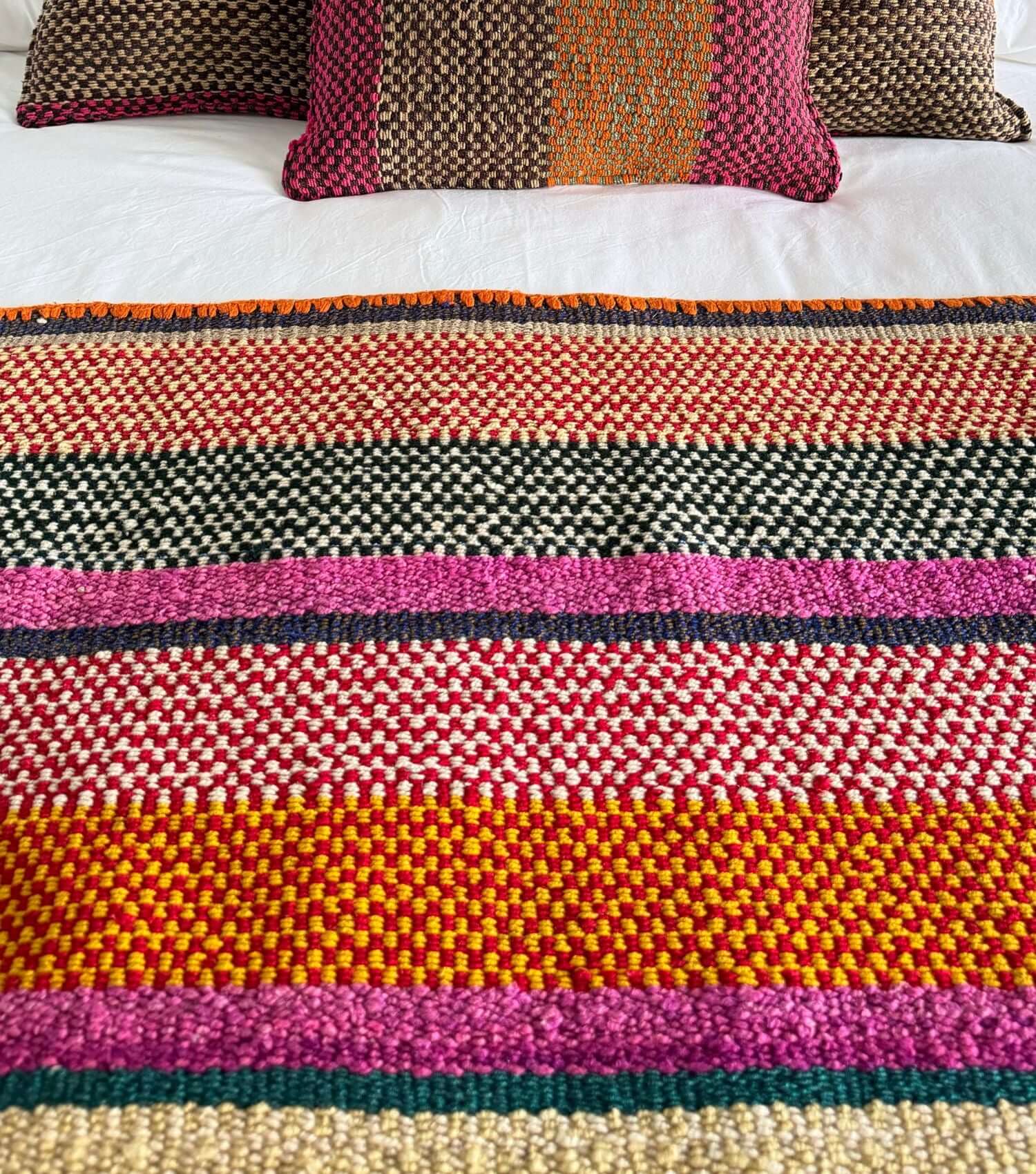 Peruvian frazada wool throw no 6 styled as bed throw and blanket showing bohemian pattern in orange, yellow, brown and pink