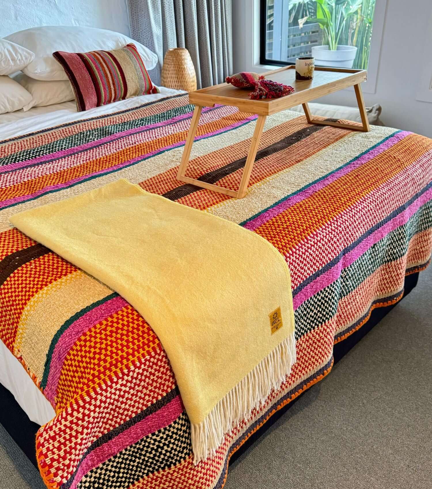 Peruvian wool throw no 6 styled as bed throw and blanket showing bohemian pattern in orange, yellow, brown and pink