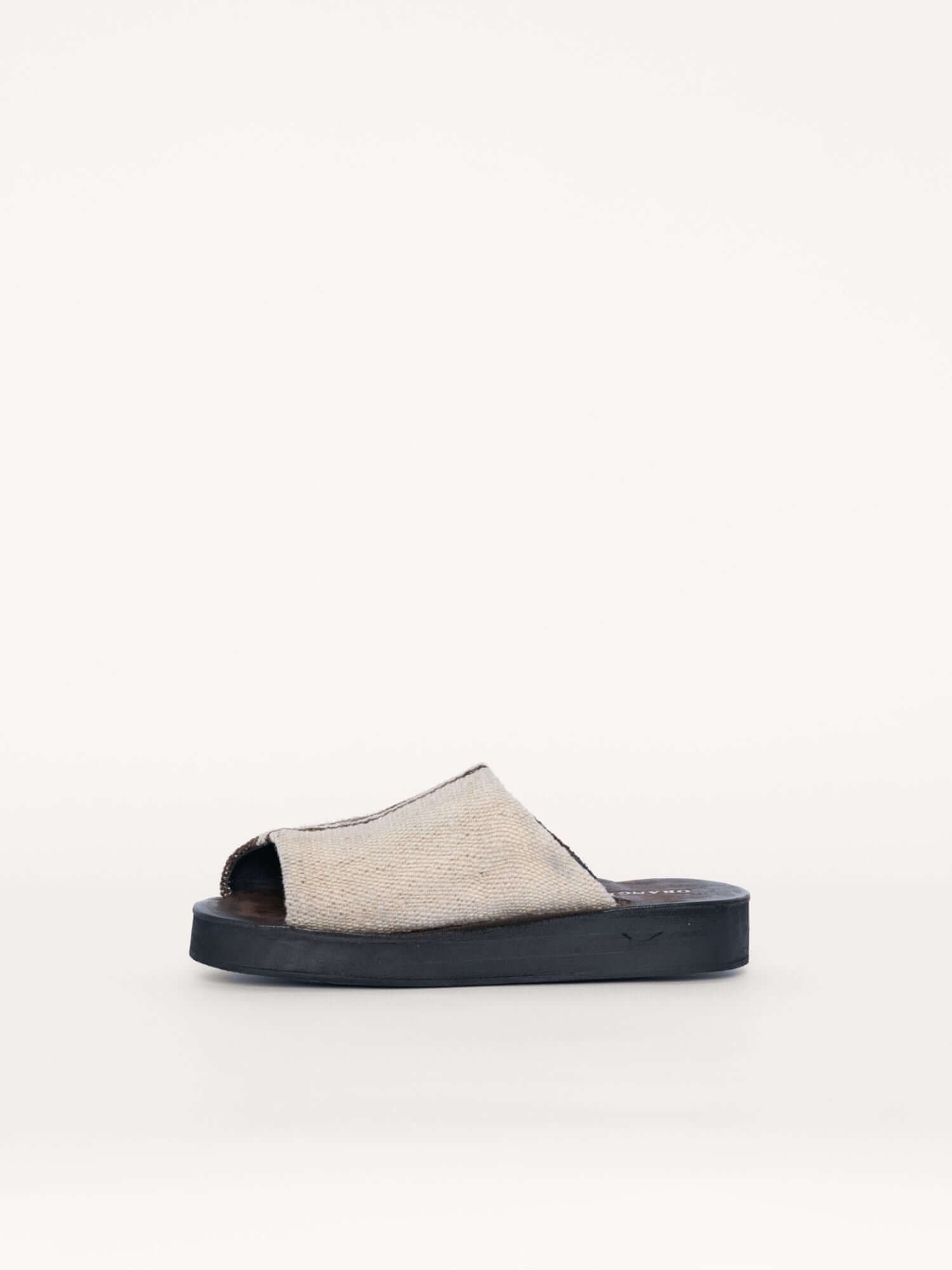 Handmade suede and wool clogs for women and men in brown and ivory, left side view.