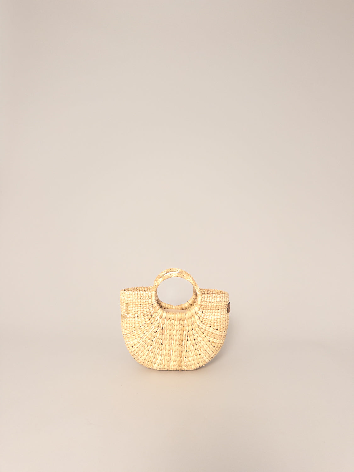 The Fiesta Mini Deluxe - Natural handwoven junco crossbody bag in natural colour with round handle.
