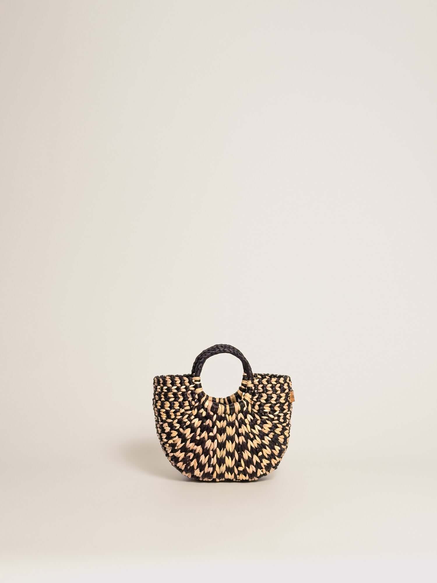 The Fiesta Mini Deluxe - Checkered Black and Natural handwoven junco crossbody bag with round handle and black stripes.