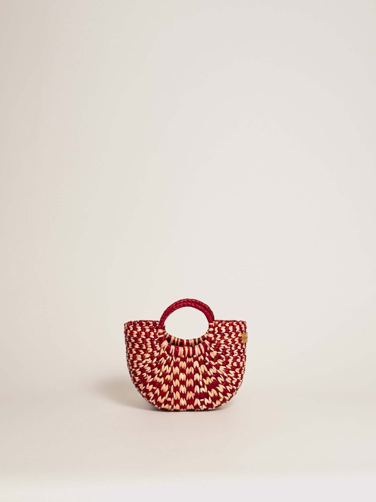 The Fiesta Mini Deluxe - Checkered Burgundy and Natural handwoven junco crossbody bag with a round handle.
