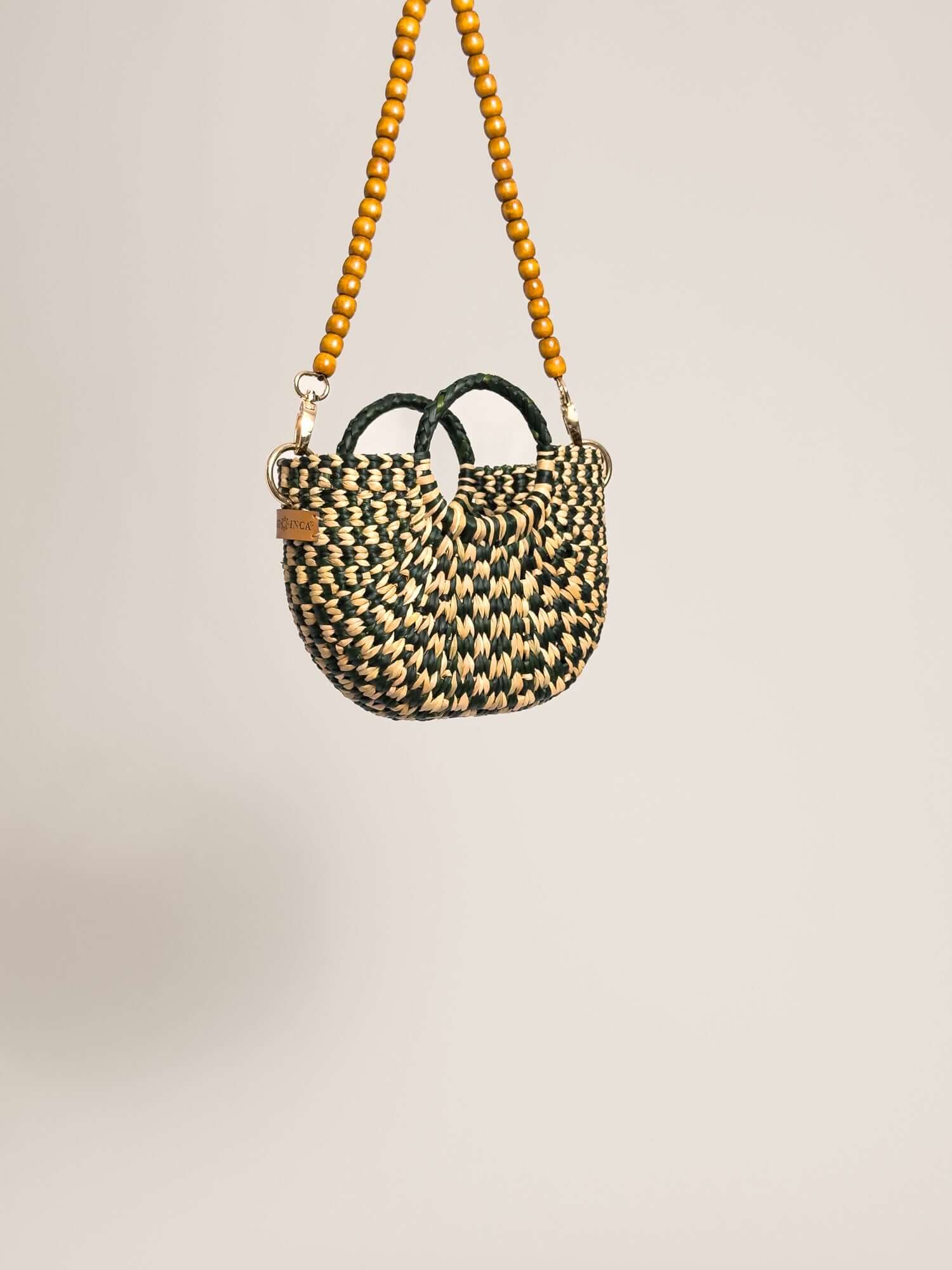 The Fiesta Mini Deluxe - Checkered Olive Green and Natural handwoven junco crossbody bag with wooden beads strap.