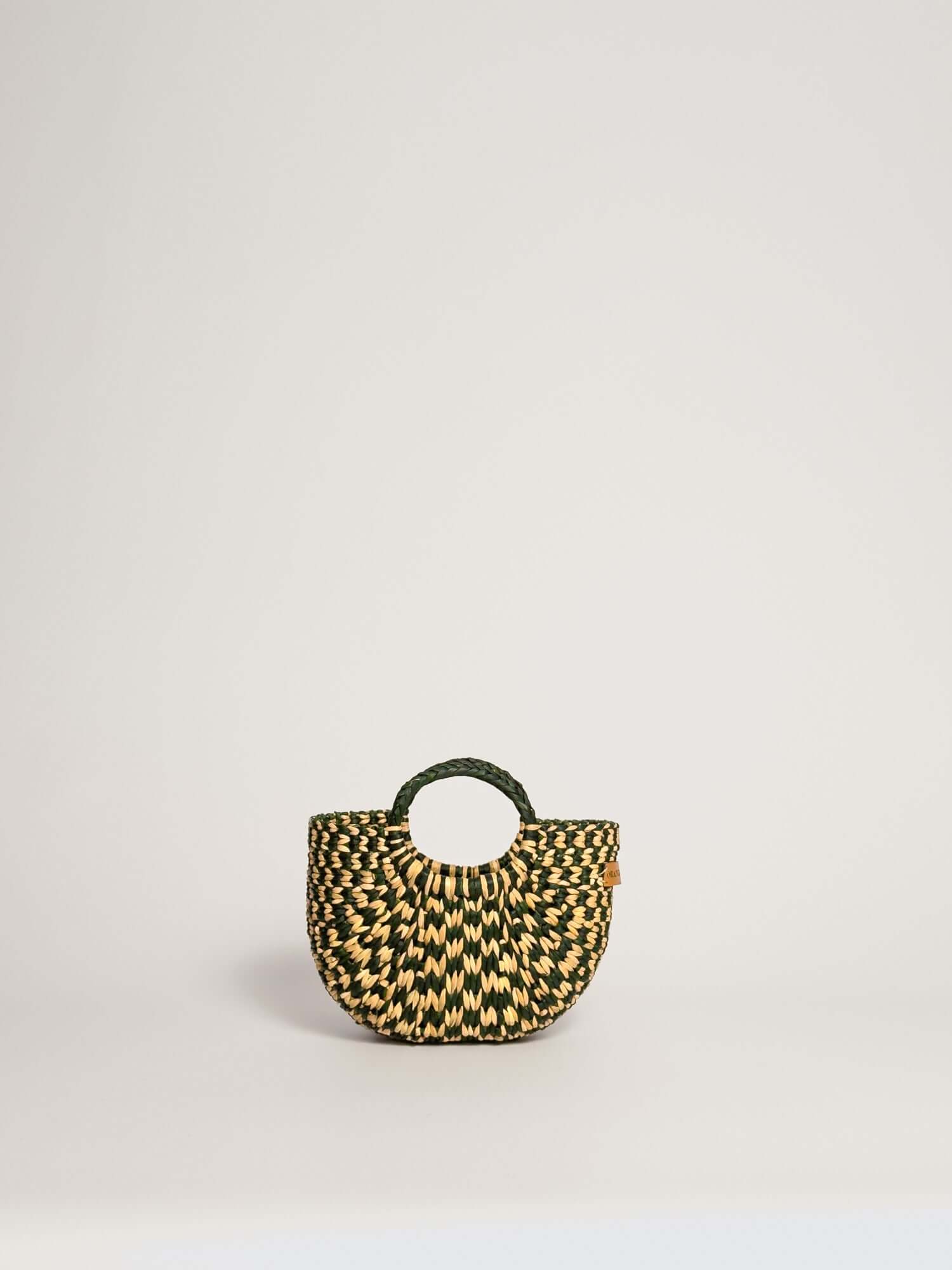 The Fiesta Mini Deluxe - Checkered Olive Green and Natural handwoven junco crossbody bag with circular handle.