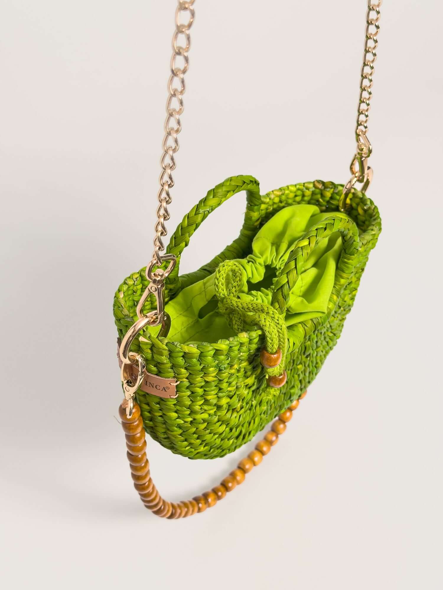 The Fiesta Mini Deluxe - Lime Green handwoven junco crossbody bag with chain and wooden bead strap.