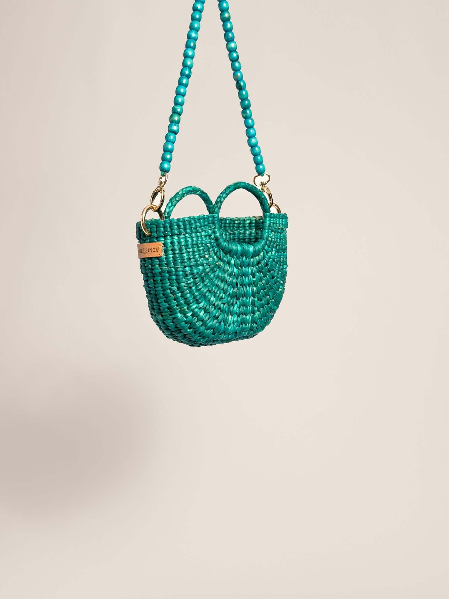 The Fiesta Mini Deluxe - Turquoise handwoven junco crossbody bag with turquoise bead strap and double handles.