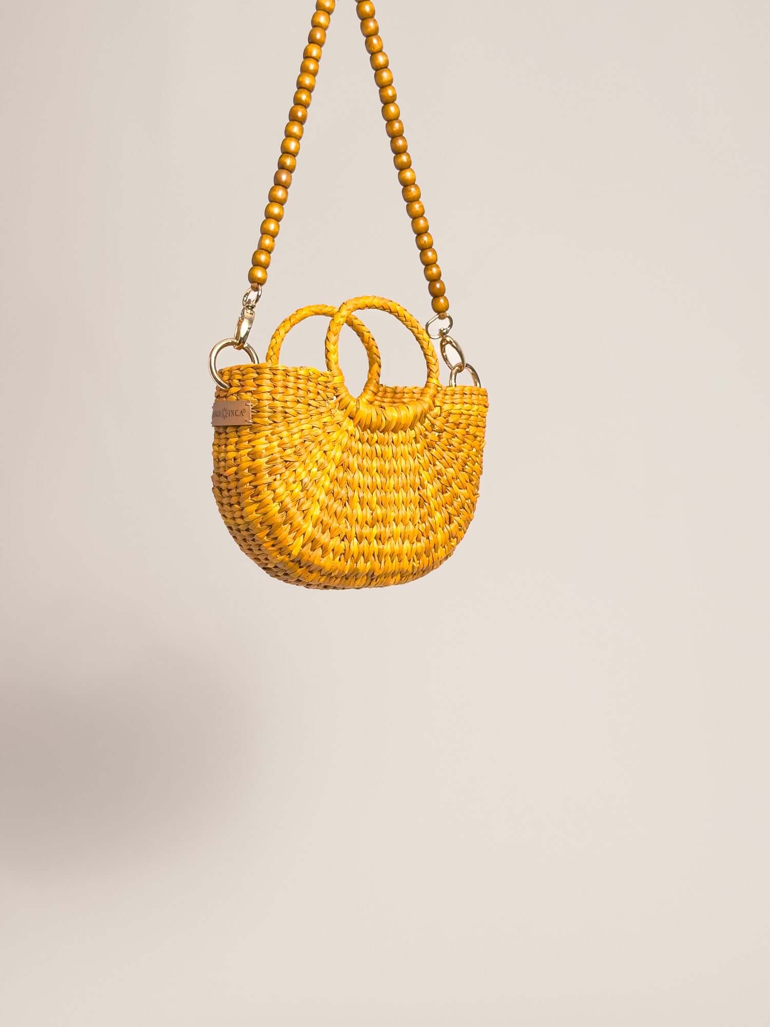 The Fiesta Mini Deluxe - Yellow handwoven junco crossbody bag with wooden beads strap and double handles.