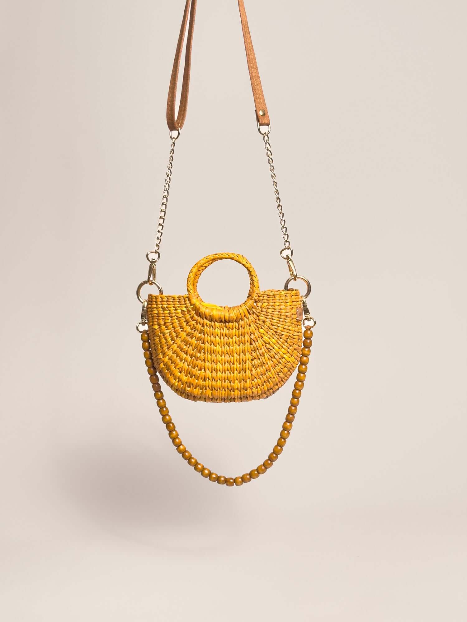 The Fiesta Mini Deluxe - Yellow handwoven junco crossbody bag with wooden beads strap and chain accents.