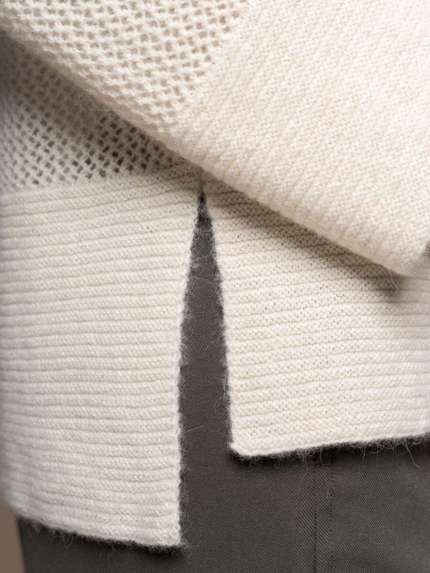 Close-up of open weave texture on ivory jumper cuff and sleeve detail