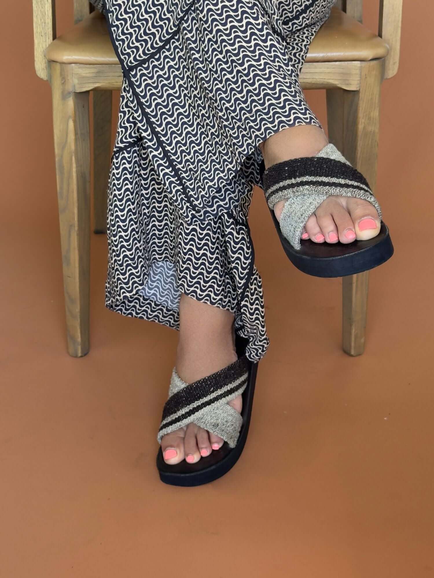 Handmade wool and leather x sandals in brown and ivory, lifestyle shot.