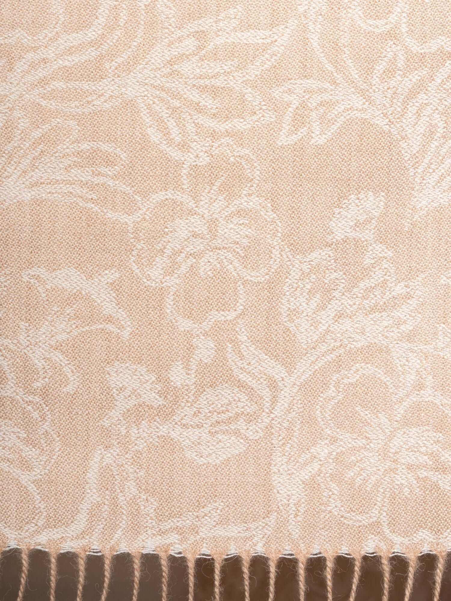 Flat lay of undyed baby alpaca floral jacquard scarf in beige, soft lightweight wrap with fringed edges and botanical pattern