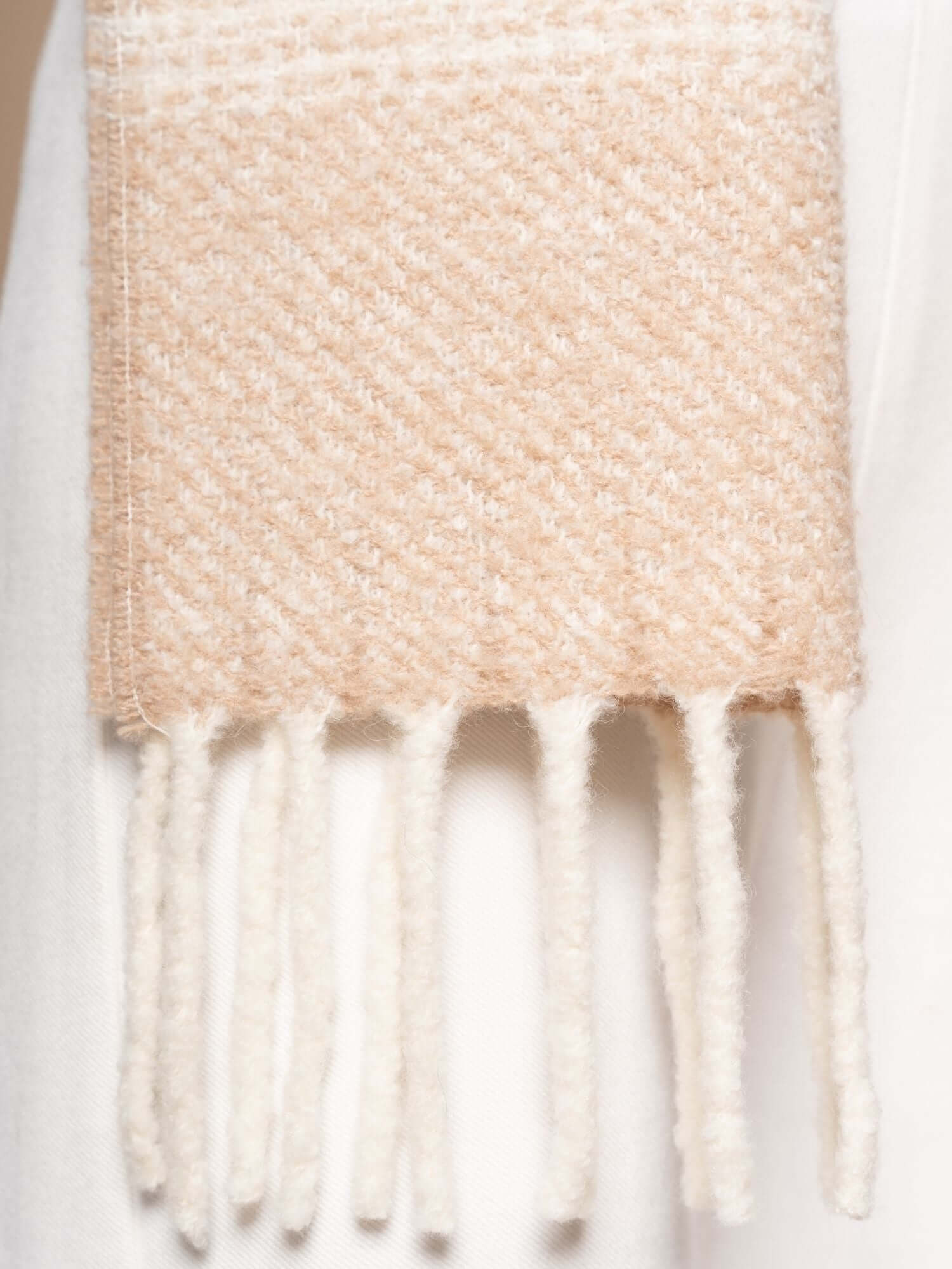 Close-up of bouclé striped scarf, soft wool blend texture with fringes