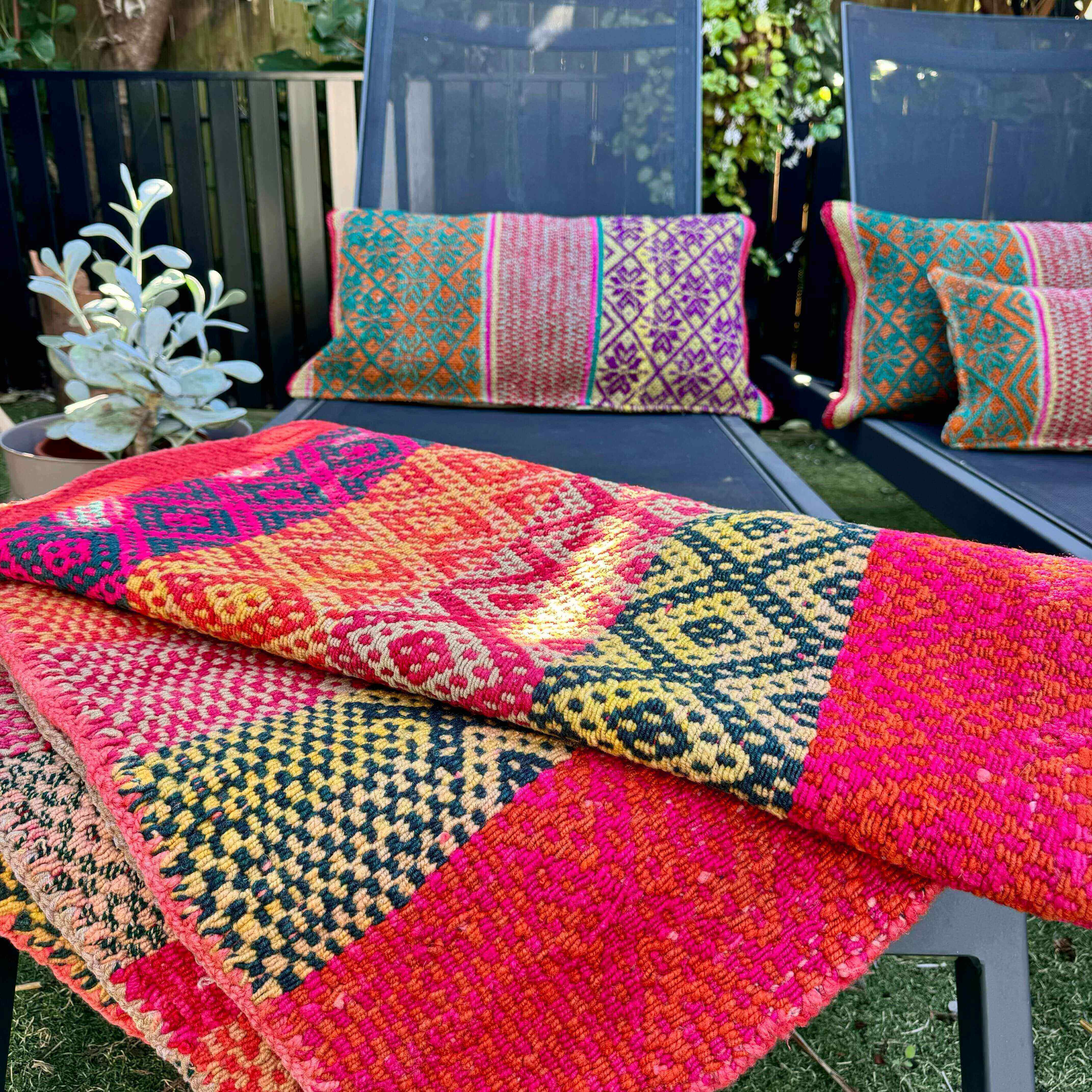 Beautiful Signature Peruvian Frazada on a sunbed, in a tropical garden. A beautiful setting to brighten up those neutral charcoal sunloungers. And how beautiful are they when surrounded by greens!