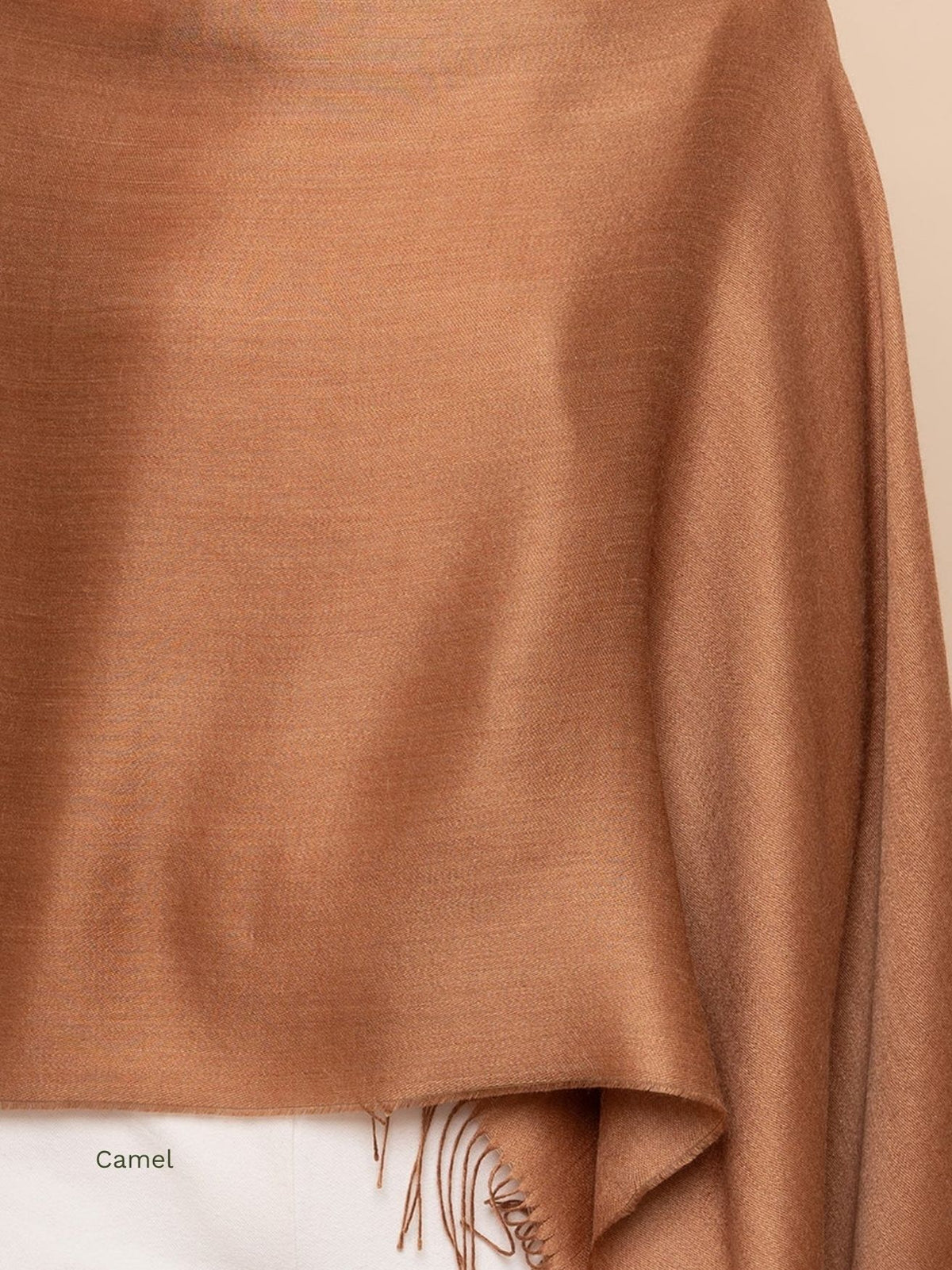 Camel silk baby alpaca blend shawl draped over the shoulder with a fringed end, warm caramel solid colour