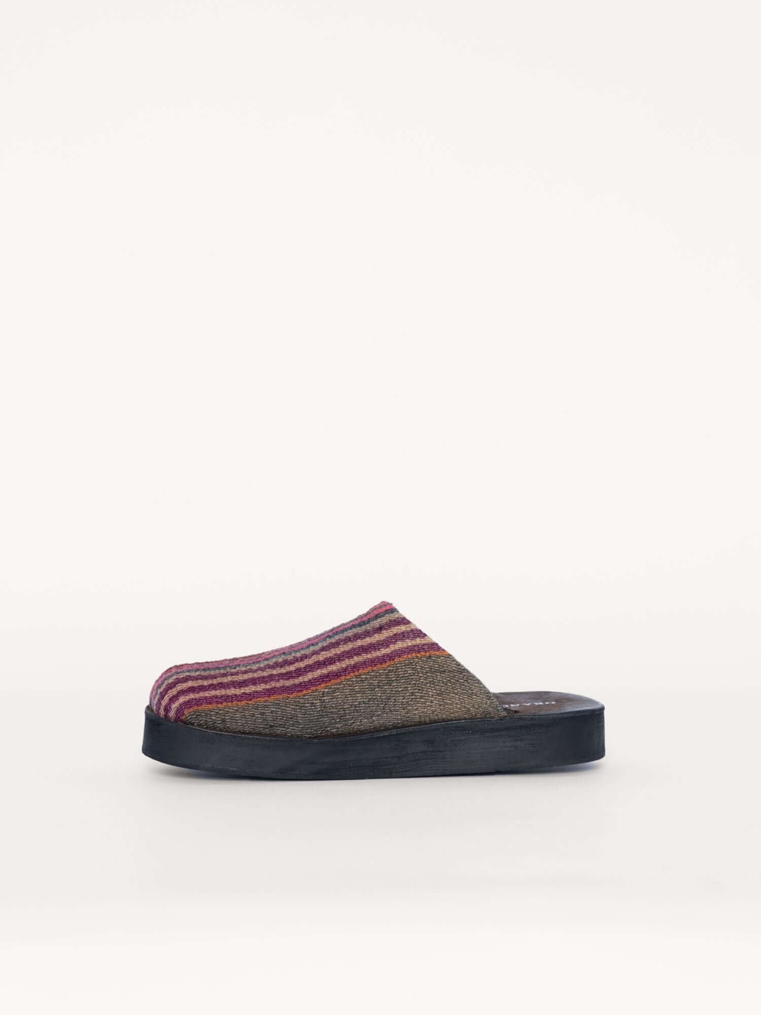 Handcrafted leather clogs with striped wool details, left side view.