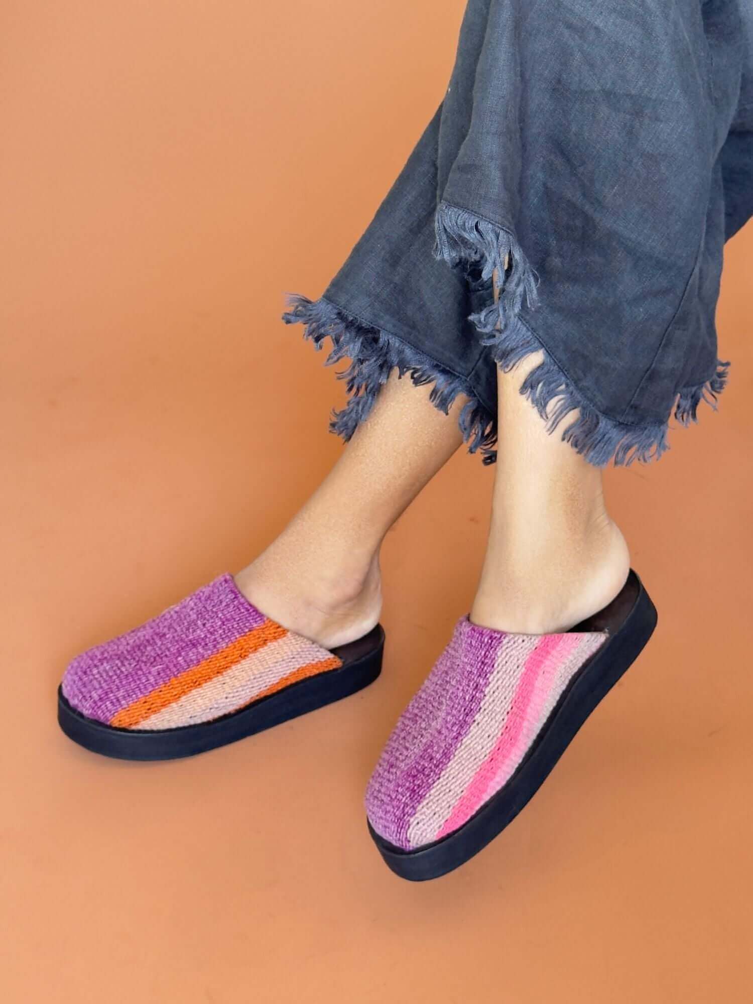 Handmade pink leather clogs with wool accents, lifestyle shot.