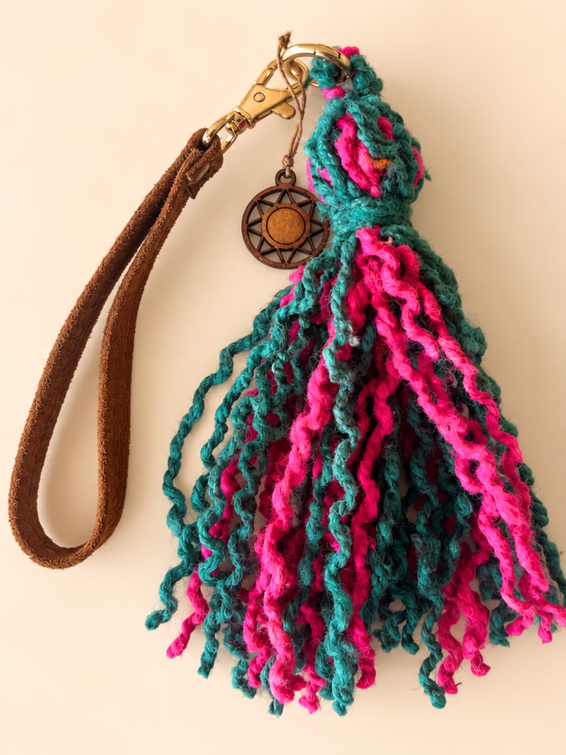 Fuchsia and green wool tassel with a faux suede wrist strap and light gold hardware