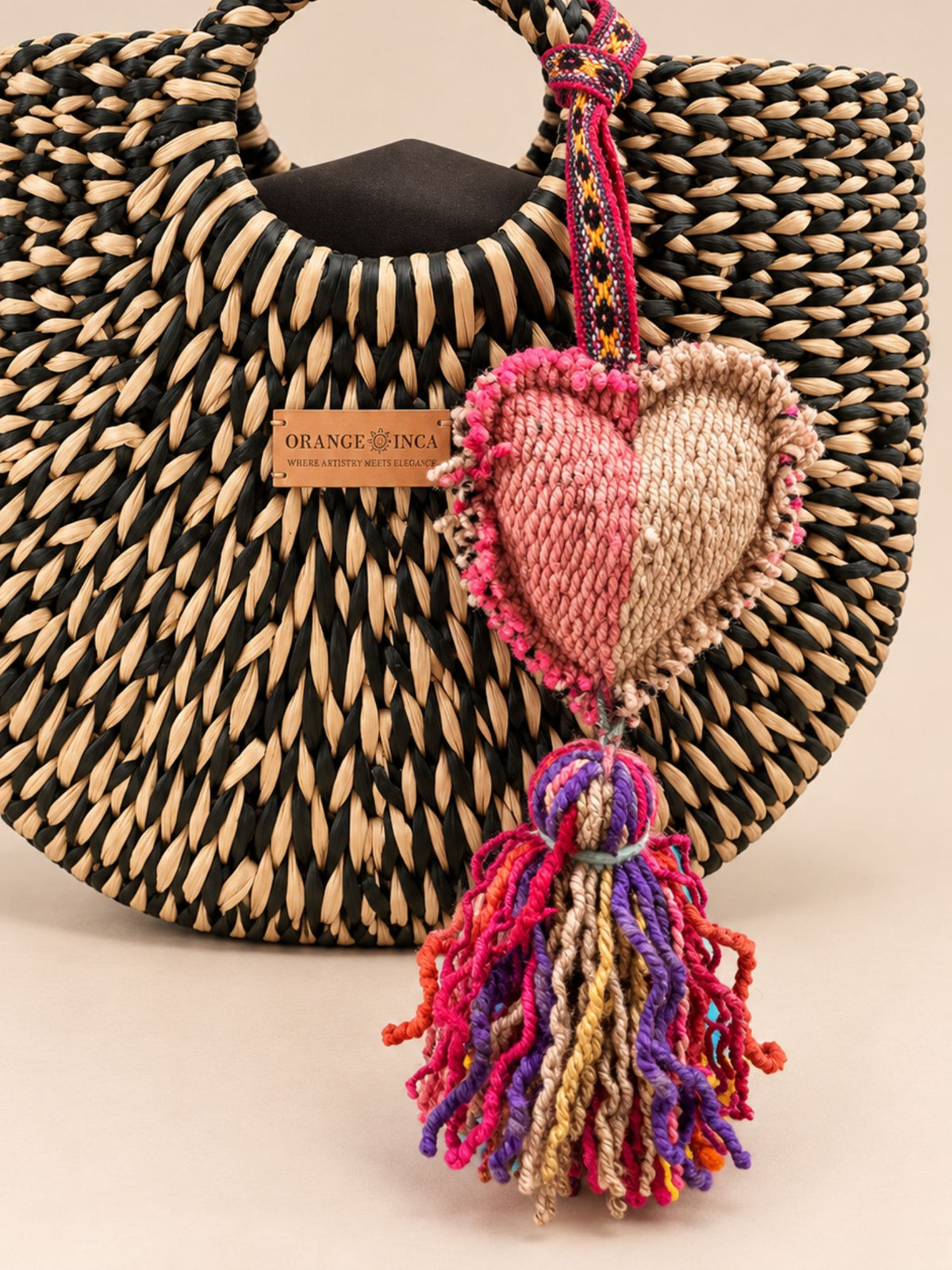 Medium heart wool tassel hanging as a charm on a woven junco handbag | Tasselita by Orange Inca