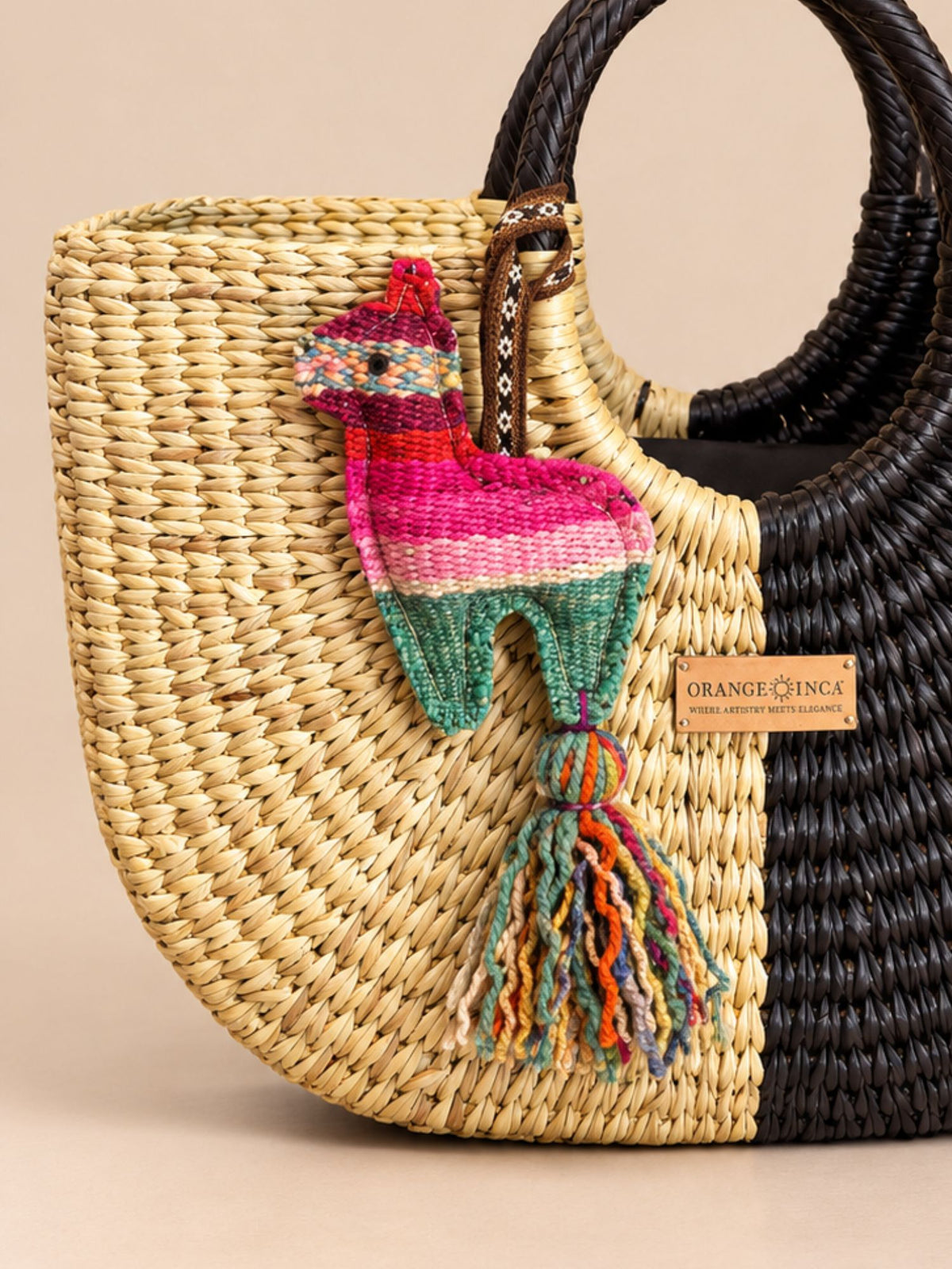 Llama wool tassel hanging as a bag charm on a black and natural woven basket bag | Tasselita by Orange Inca