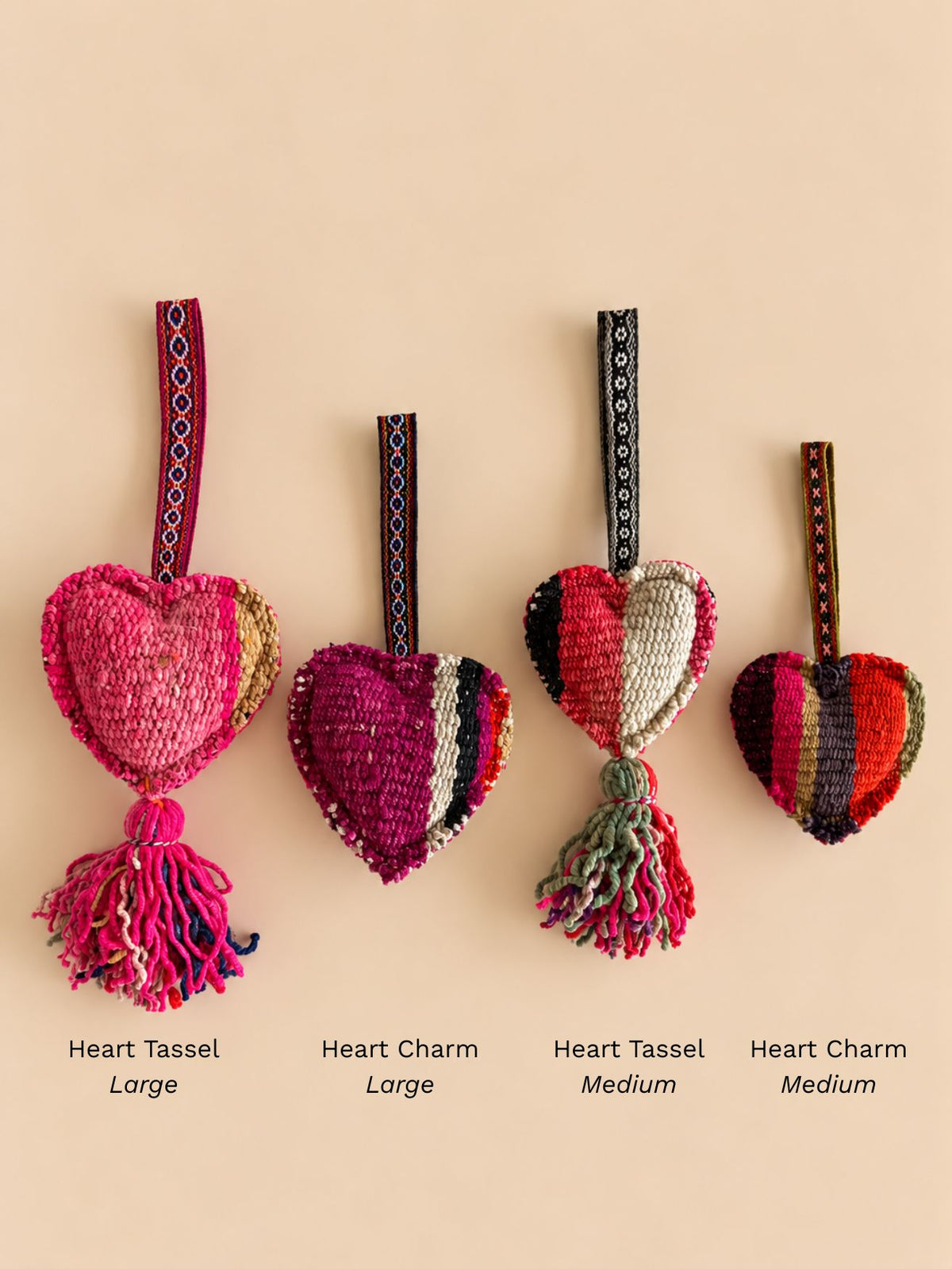 Four heart wool pieces in a row to compare sizes, labelled Heart Tassel Large, Heart Charm Large, Heart Tassel Medium and Heart Charm Medium | Tasselita by Orange Inca