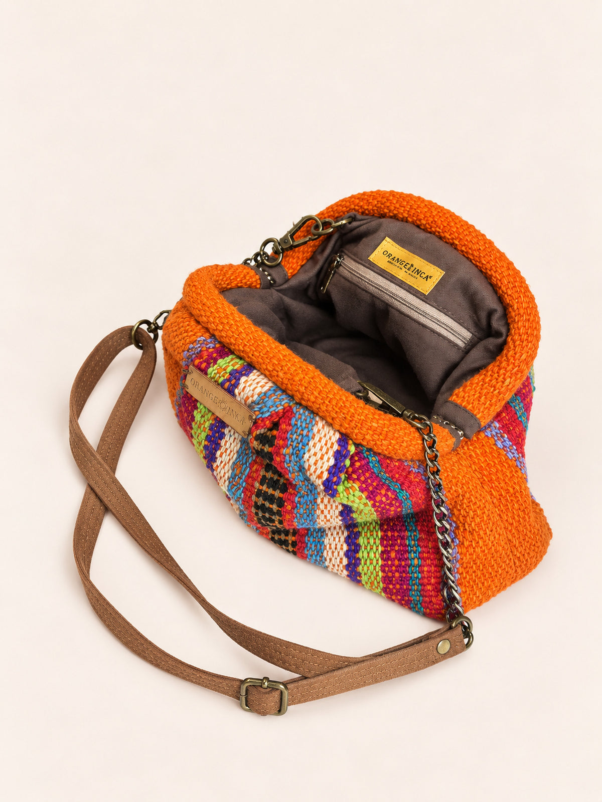 Inside the Alba kiss lock clutch in orange with rainbow stripes – cotton drill lining, zip pocket and detachable faux suede and chain strap | Orange Inca