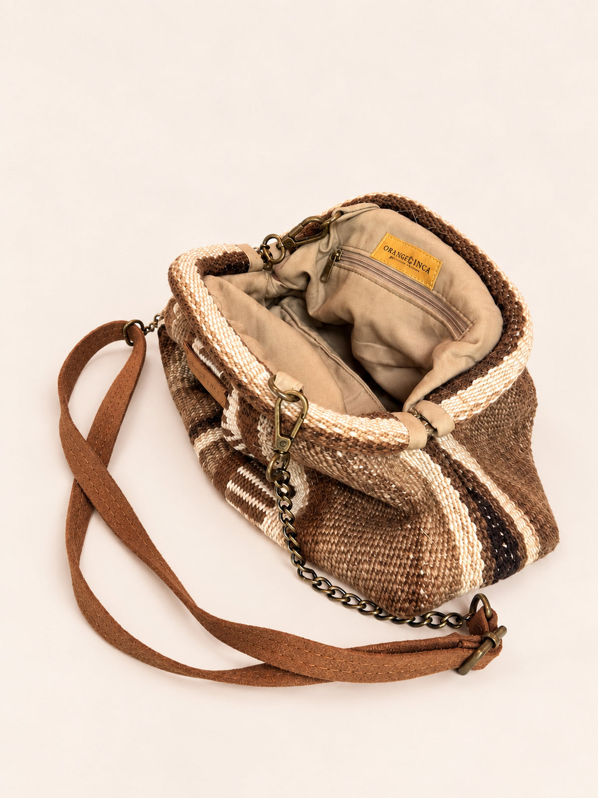 Inside the Luna kiss lock clutch in browns, ivory and burgundy – cotton drill lining, zip pocket and detachable faux suede and chain strap | Orange Inca