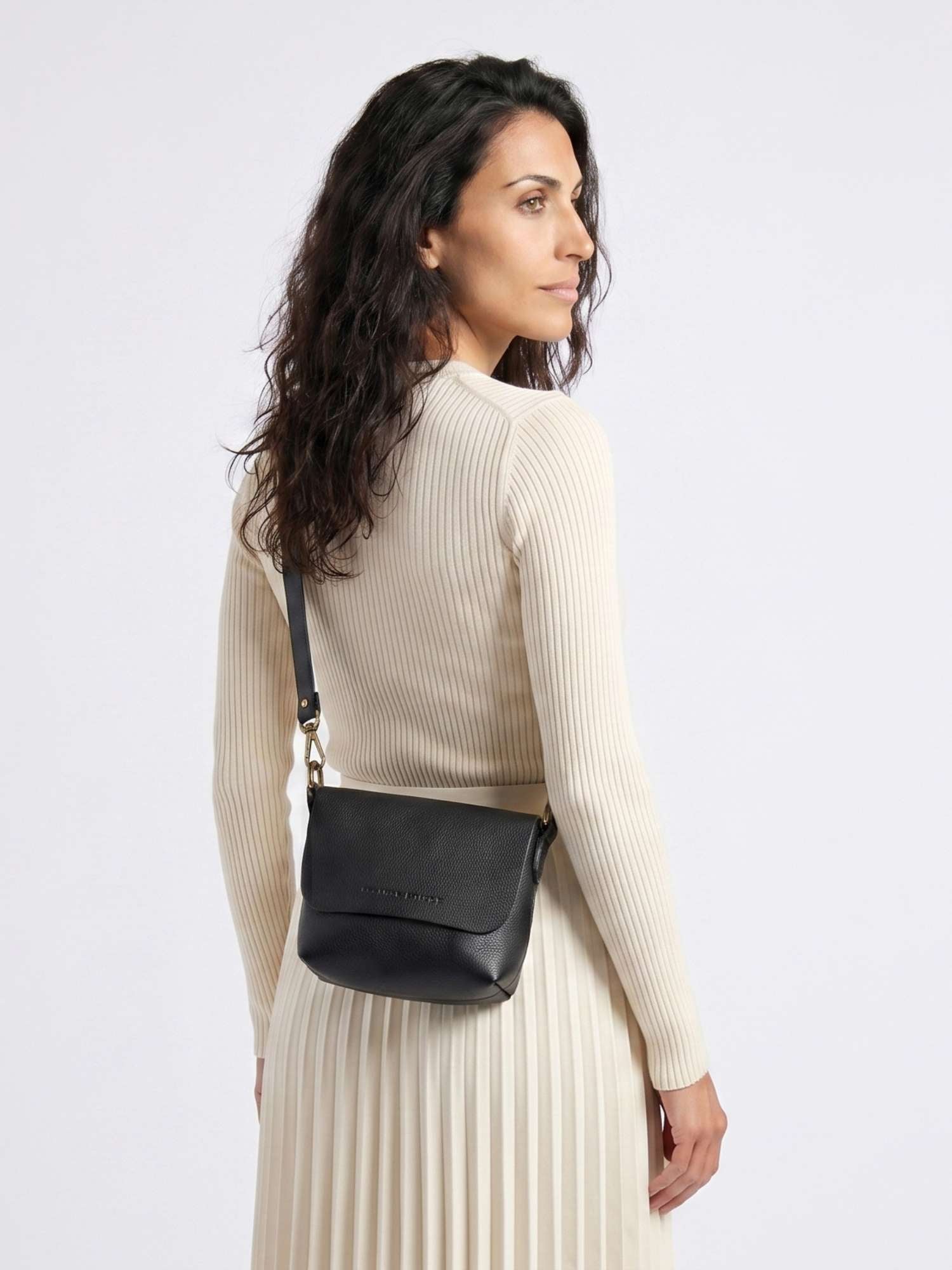 The Olivia Black leather crossbody bag worn across the body — adjustable long strap, hands-free carry | Orange Inca