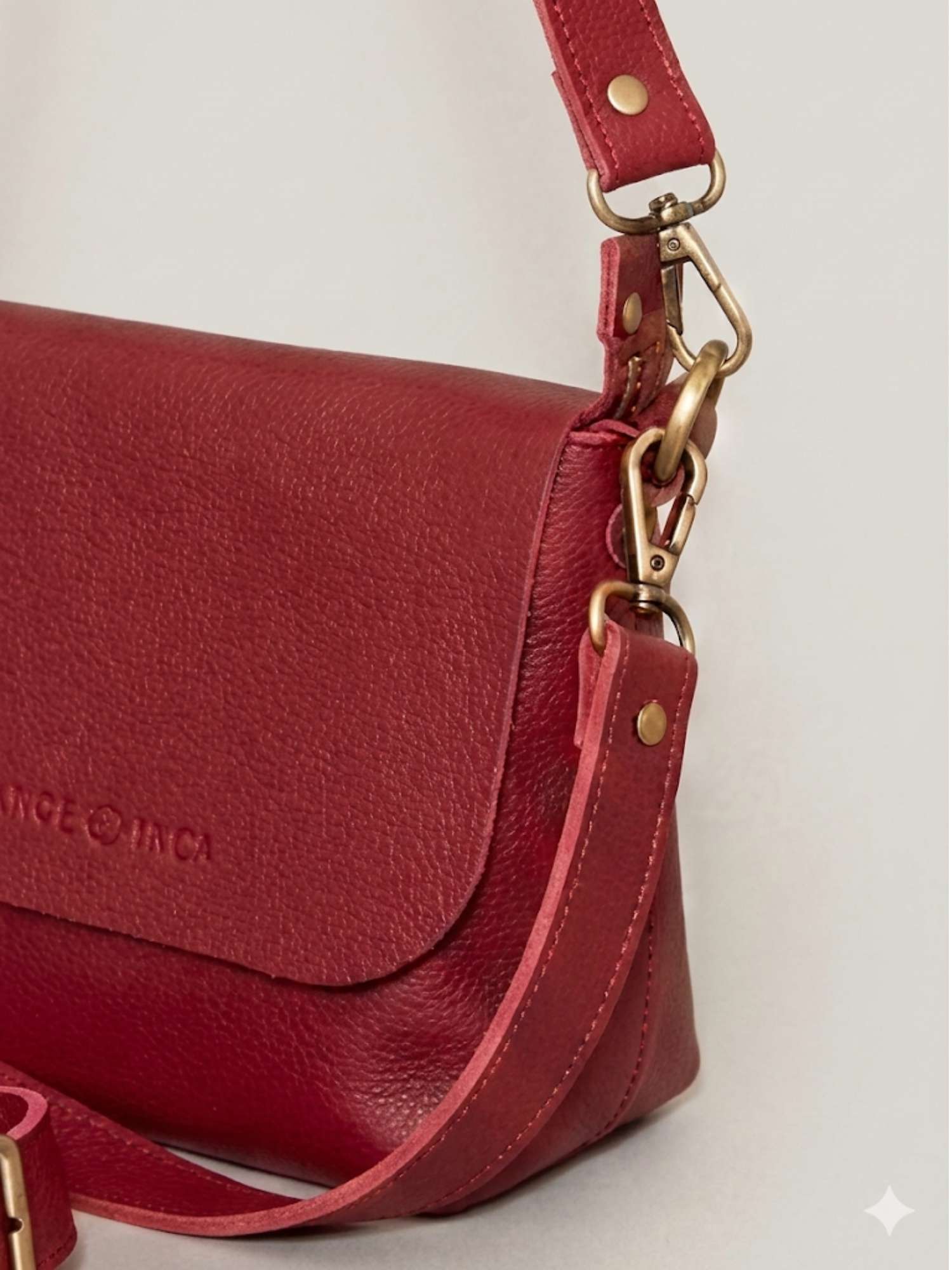 Burgundy Olivia close-up — tumbled leather detail with antique brass hardware | Orange Inca