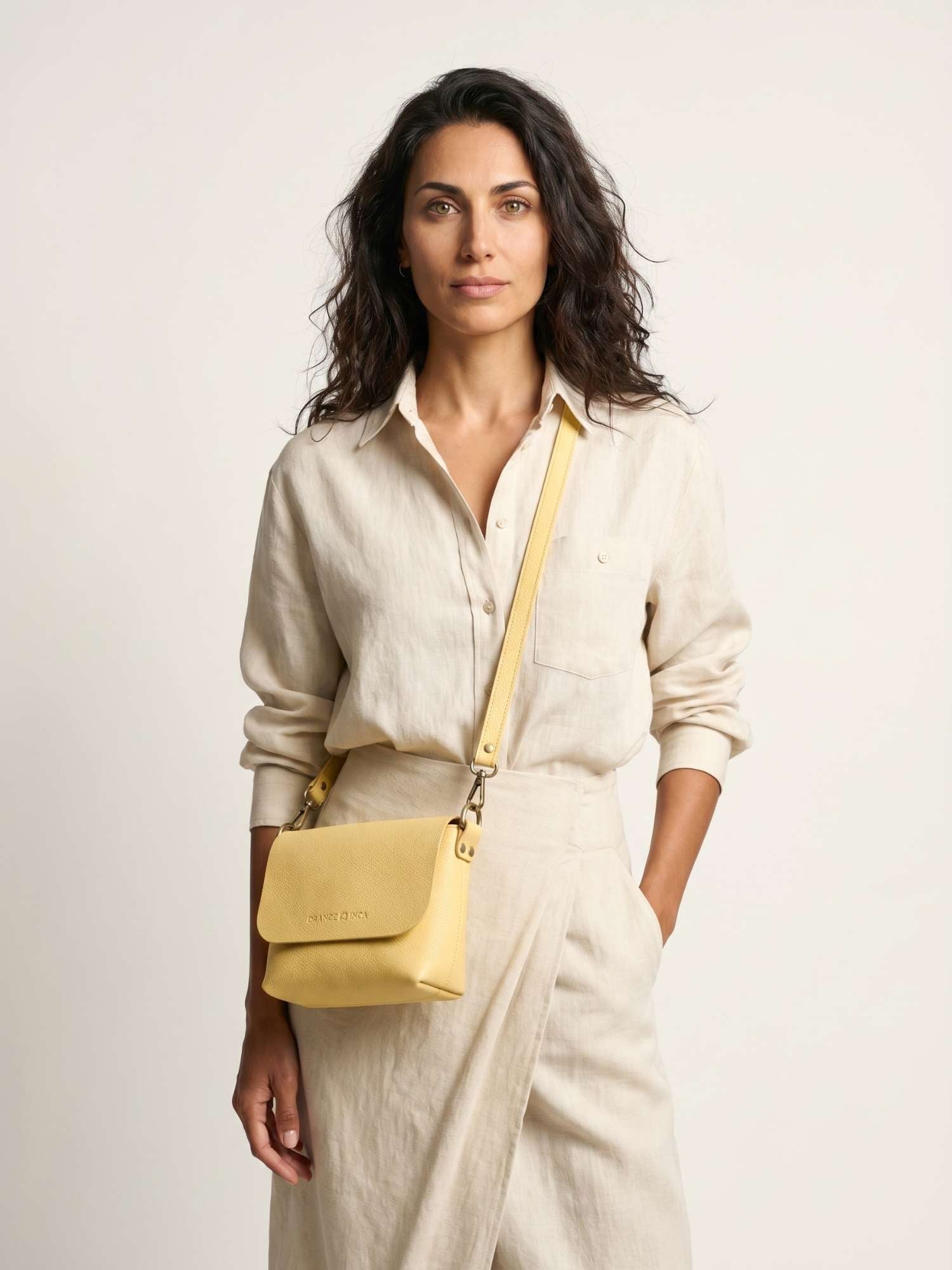 The Olivia Butter Yellow leather crossbody bag worn across the body — adjustable long strap, hands-free carry | Orange Inca