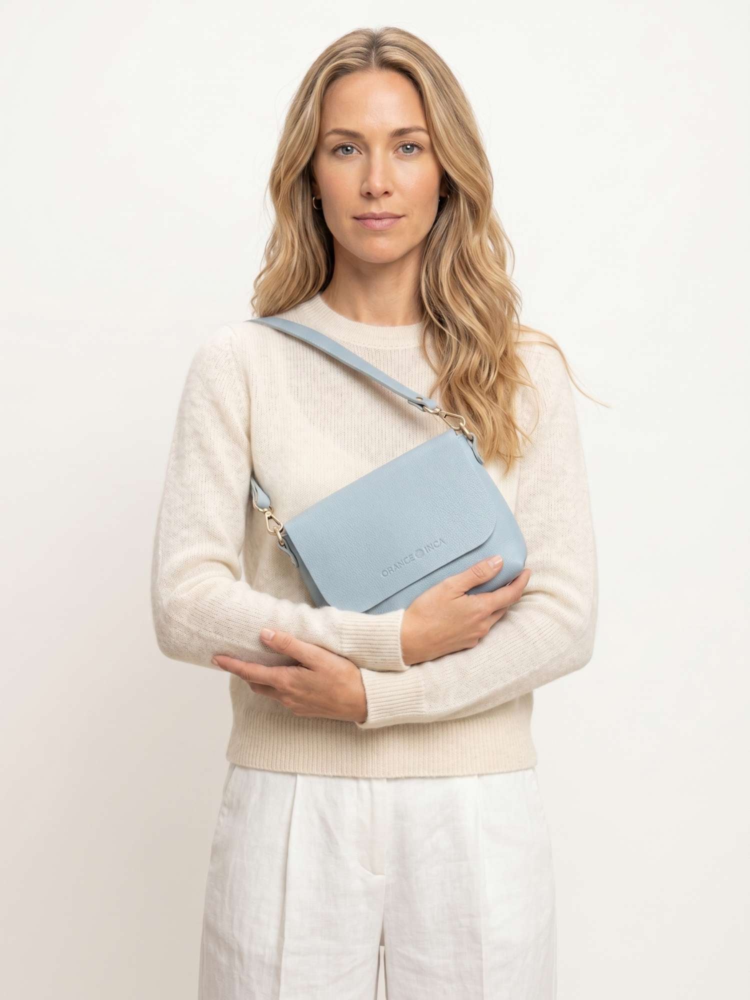 The Olivia Powder Blue leather crossbody bag worn over the shoulder with the short strap — full-grain leather | Orange Inca