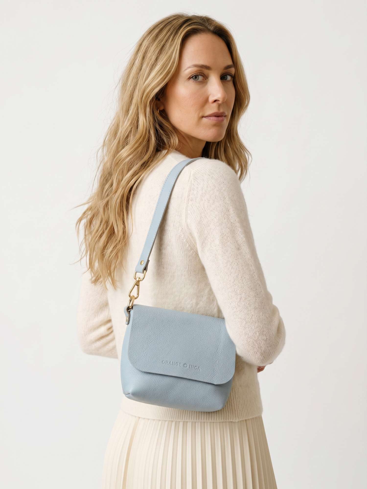 The Olivia Powder Blue leather crossbody bag — over-the-shoulder carry, side view | Orange Inca