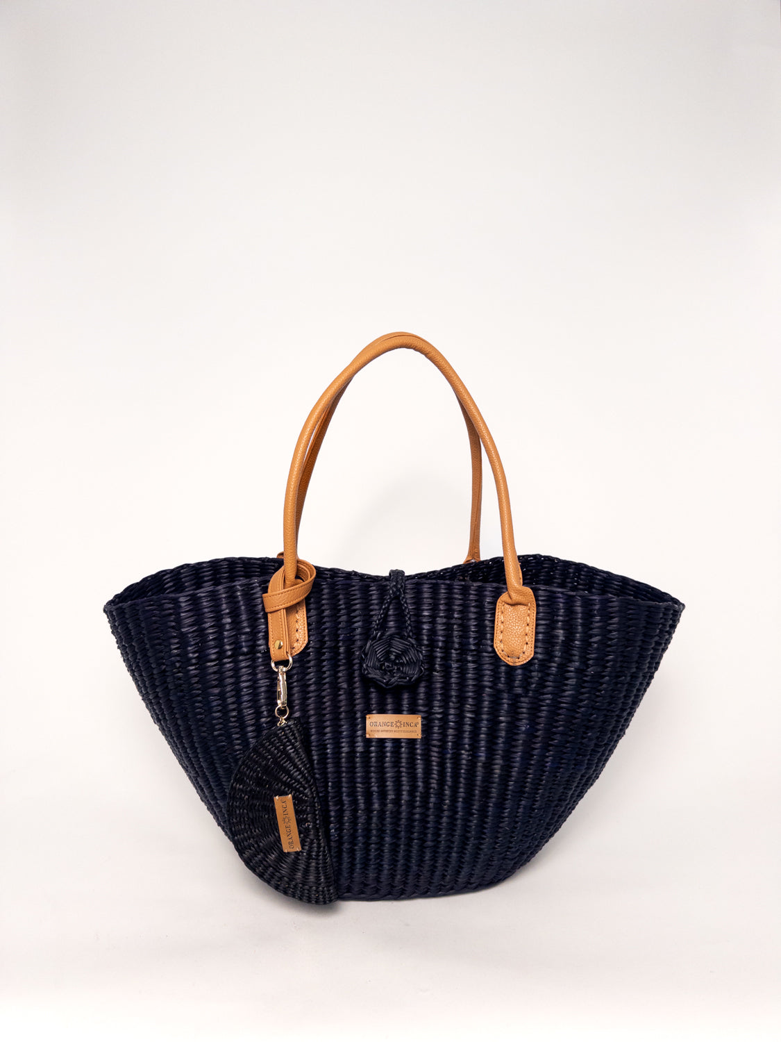 Playa Tote - Black, handwoven junco tote bag, featuring faux leather straps and a cotton-based top closure.