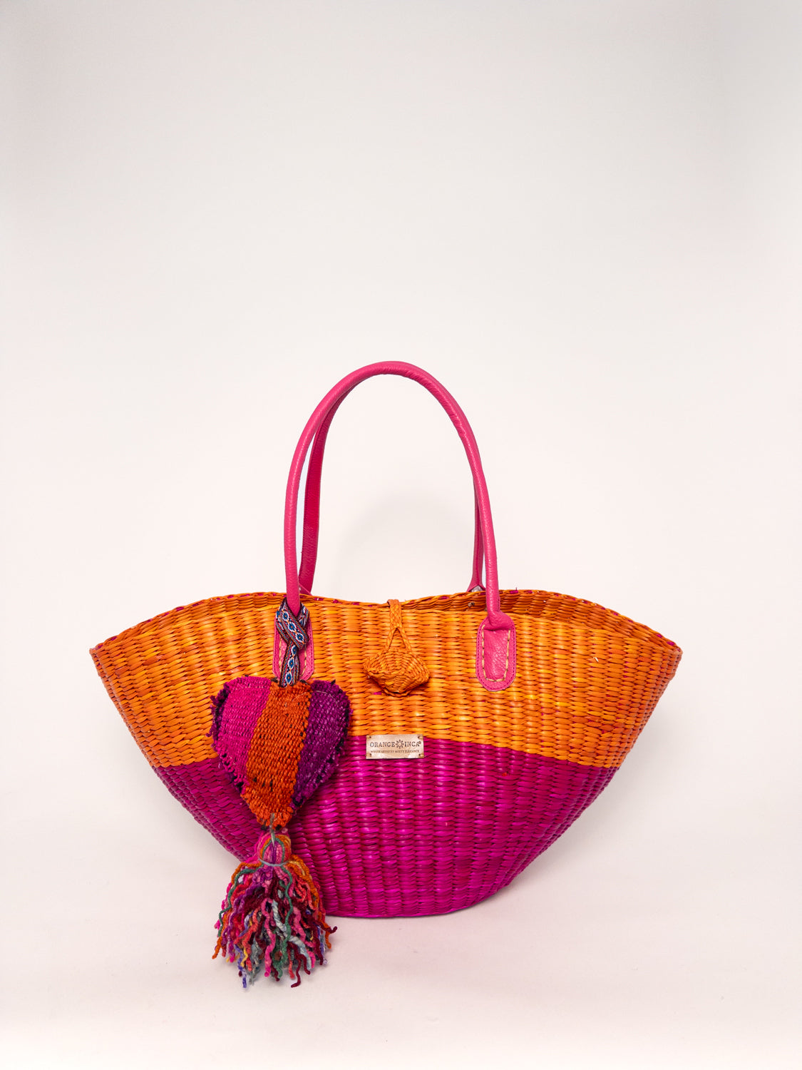 Playa Tote - Half Fuchsia Half Orange, handwoven junco tote bag with faux leather straps and colorful tassel.