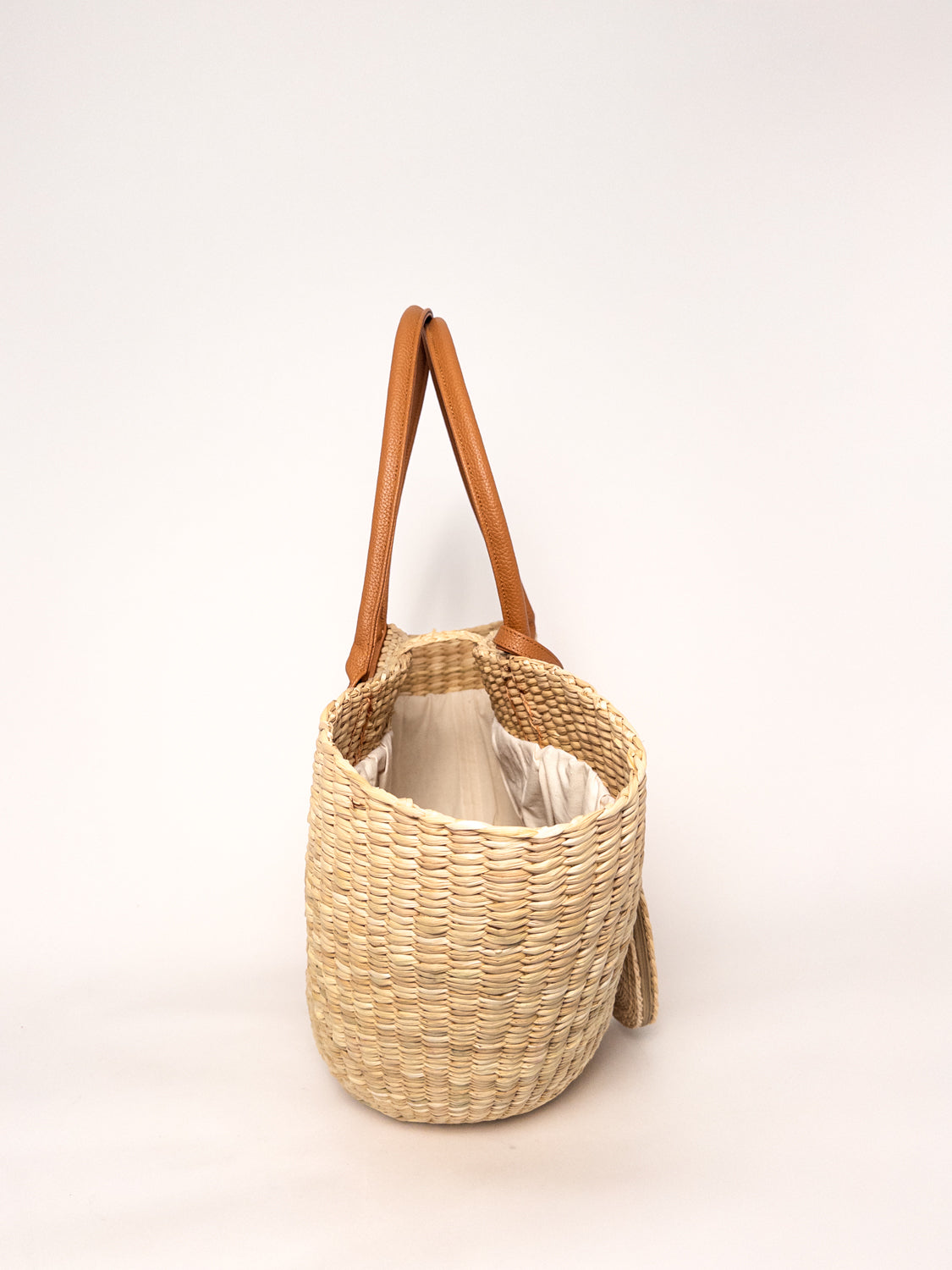 Playa Tote - Natural, handwoven junco tote bag with faux leather straps and cotton closure.