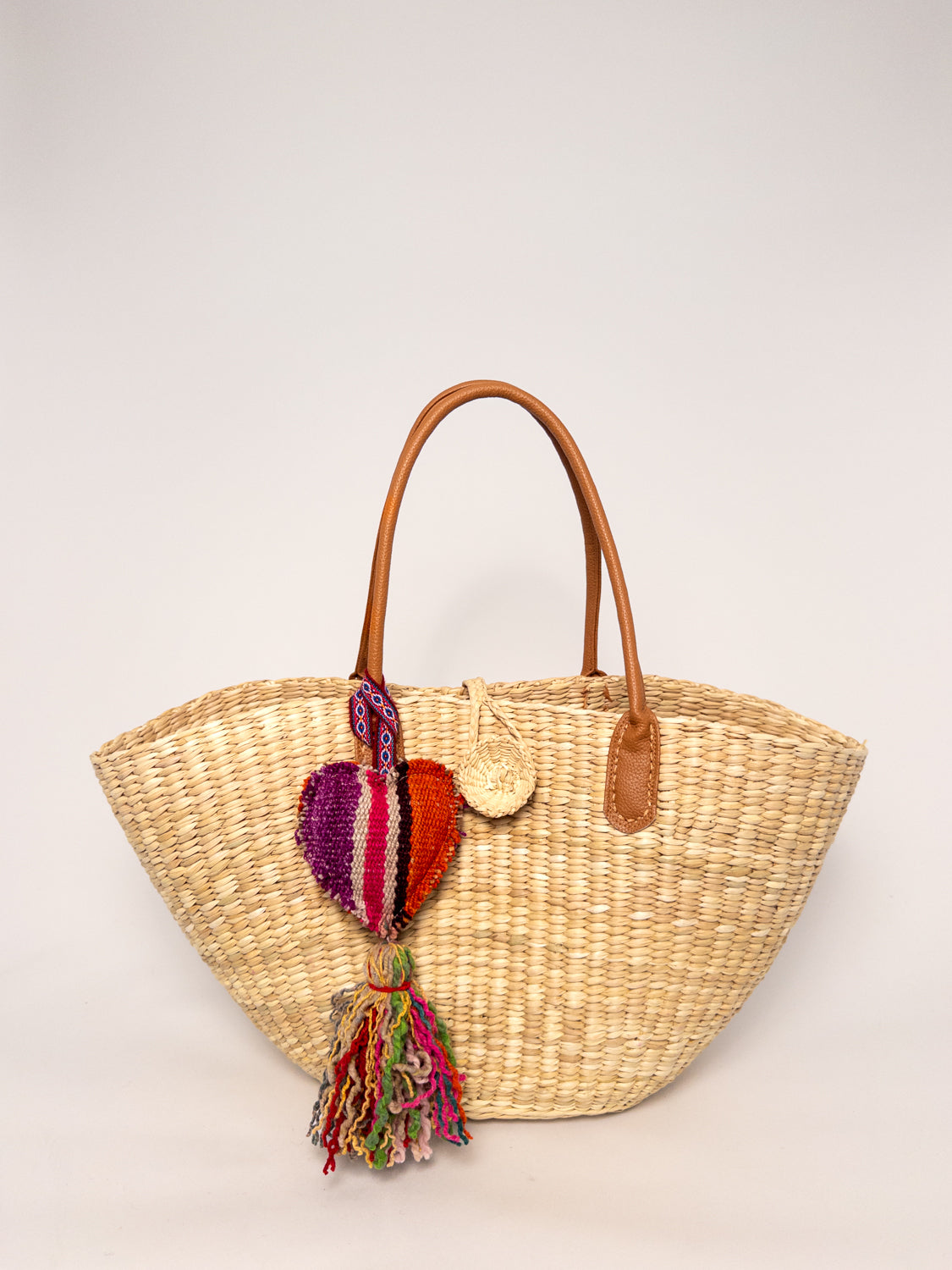 Playa Tote - Natural, handwoven junco tote bag with faux leather straps and colorful tassel.